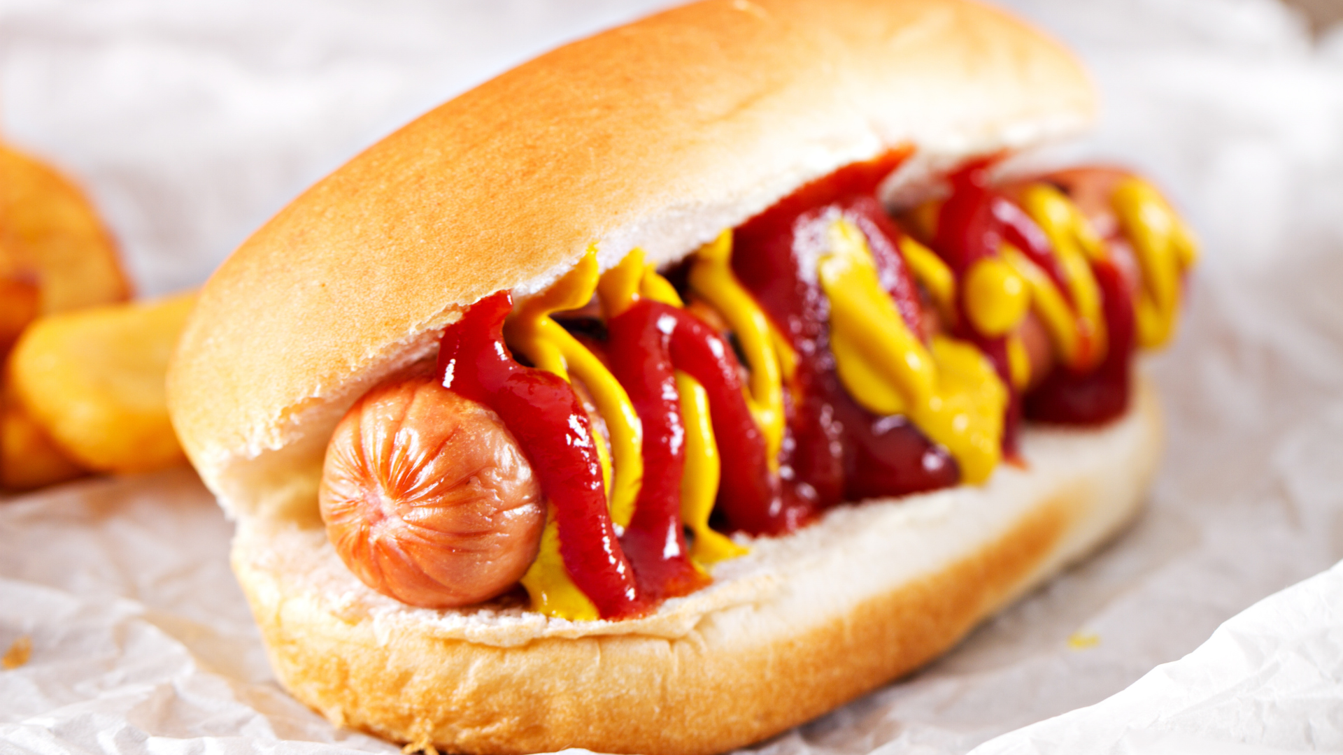 A hot dog with ketchup and mustard on a bun.
