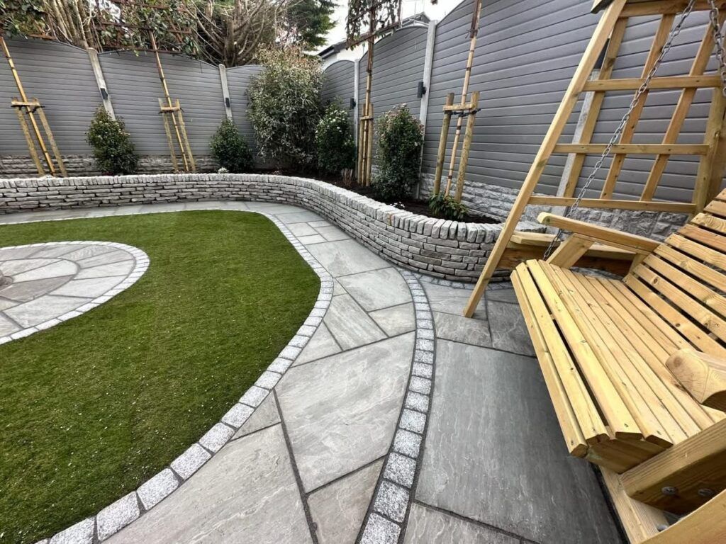 Backyard with stone pathway, artificial turf, wooden swing, and retaining wall.