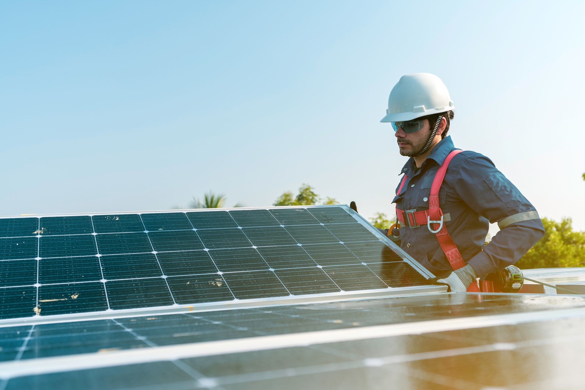 A man is working on a solar panel on top of a roof
