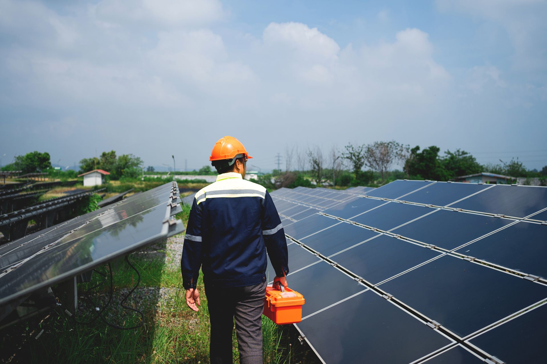 A man is walking through a field of solar panels