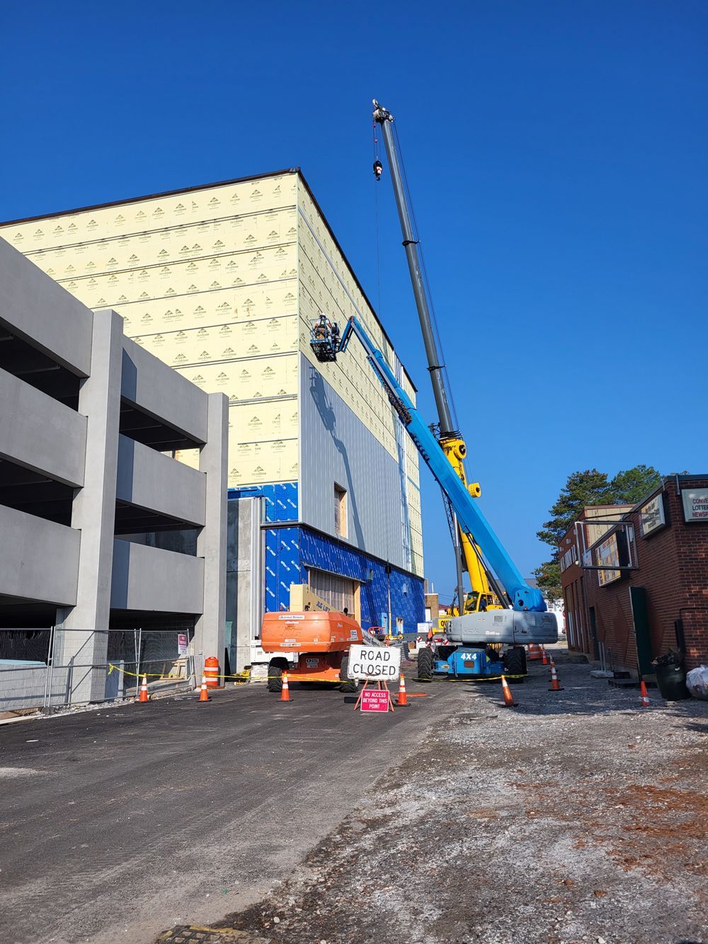A large building under construction with a crane in front of it
