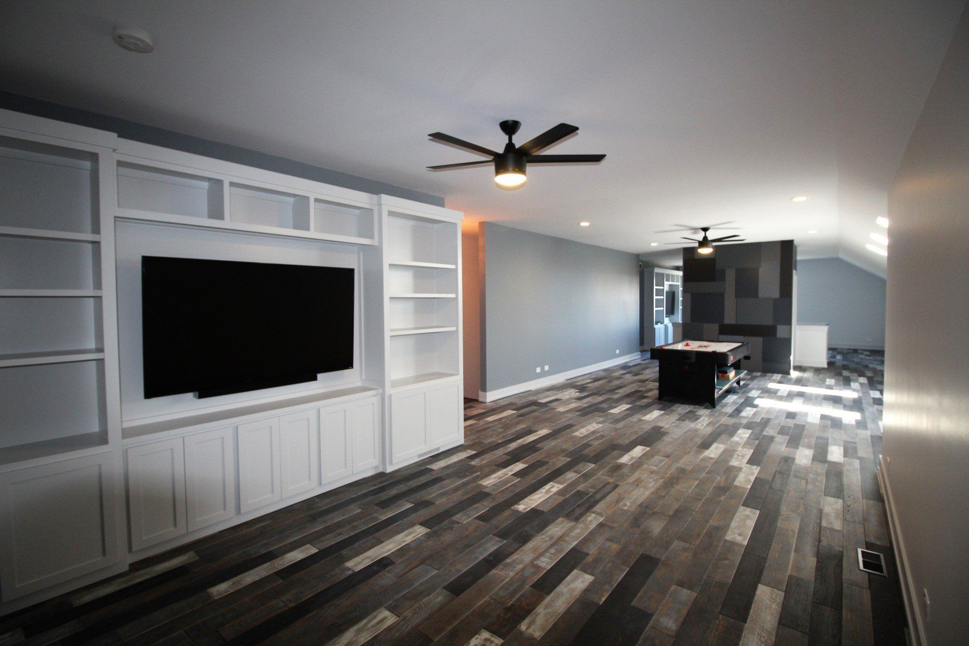 A living room with a flat screen tv and a pool table.