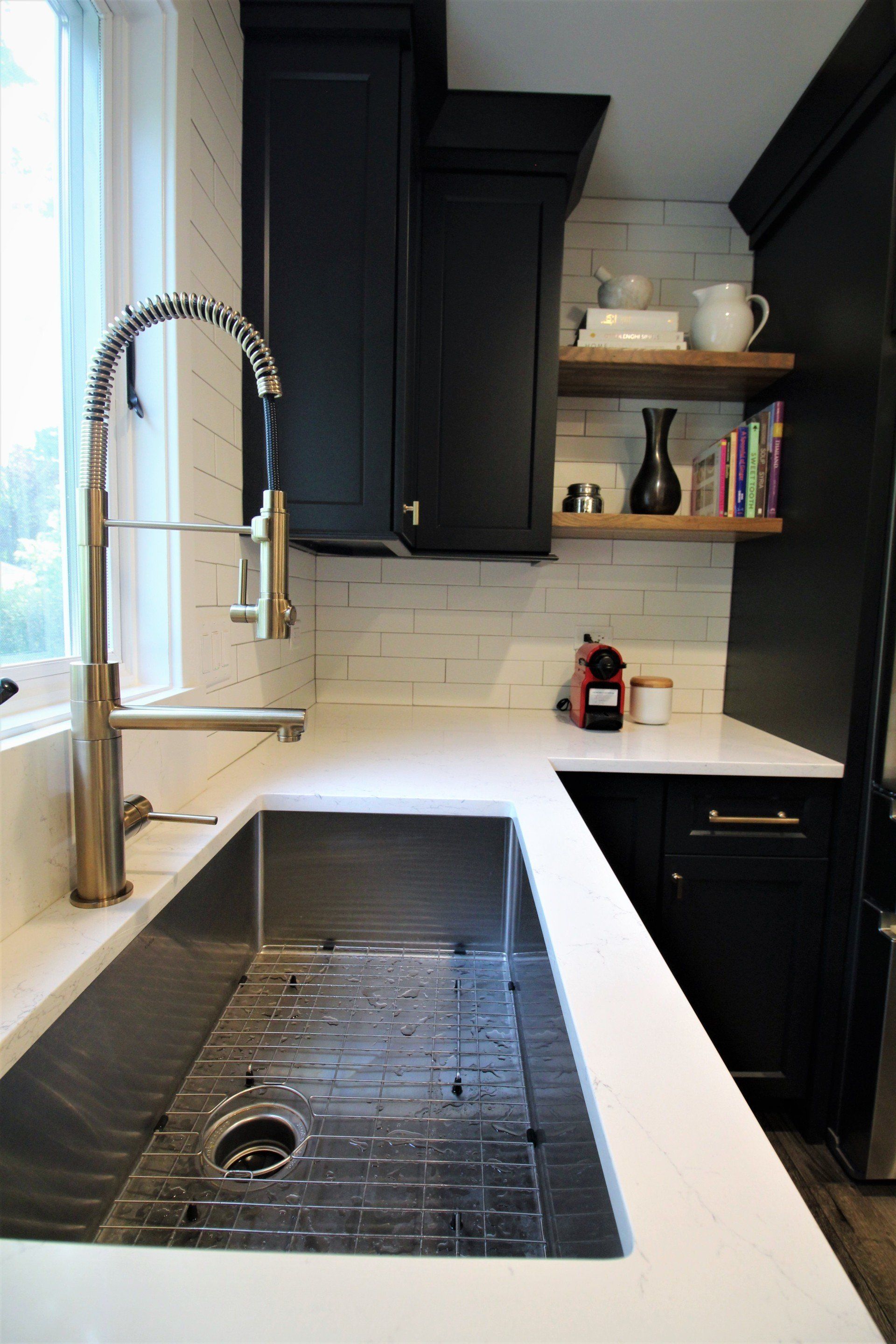A kitchen with a stainless steel sink and a faucet.