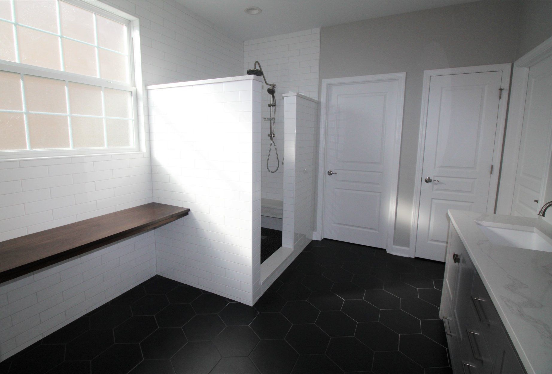 A bathroom with a walk in shower and a sink.