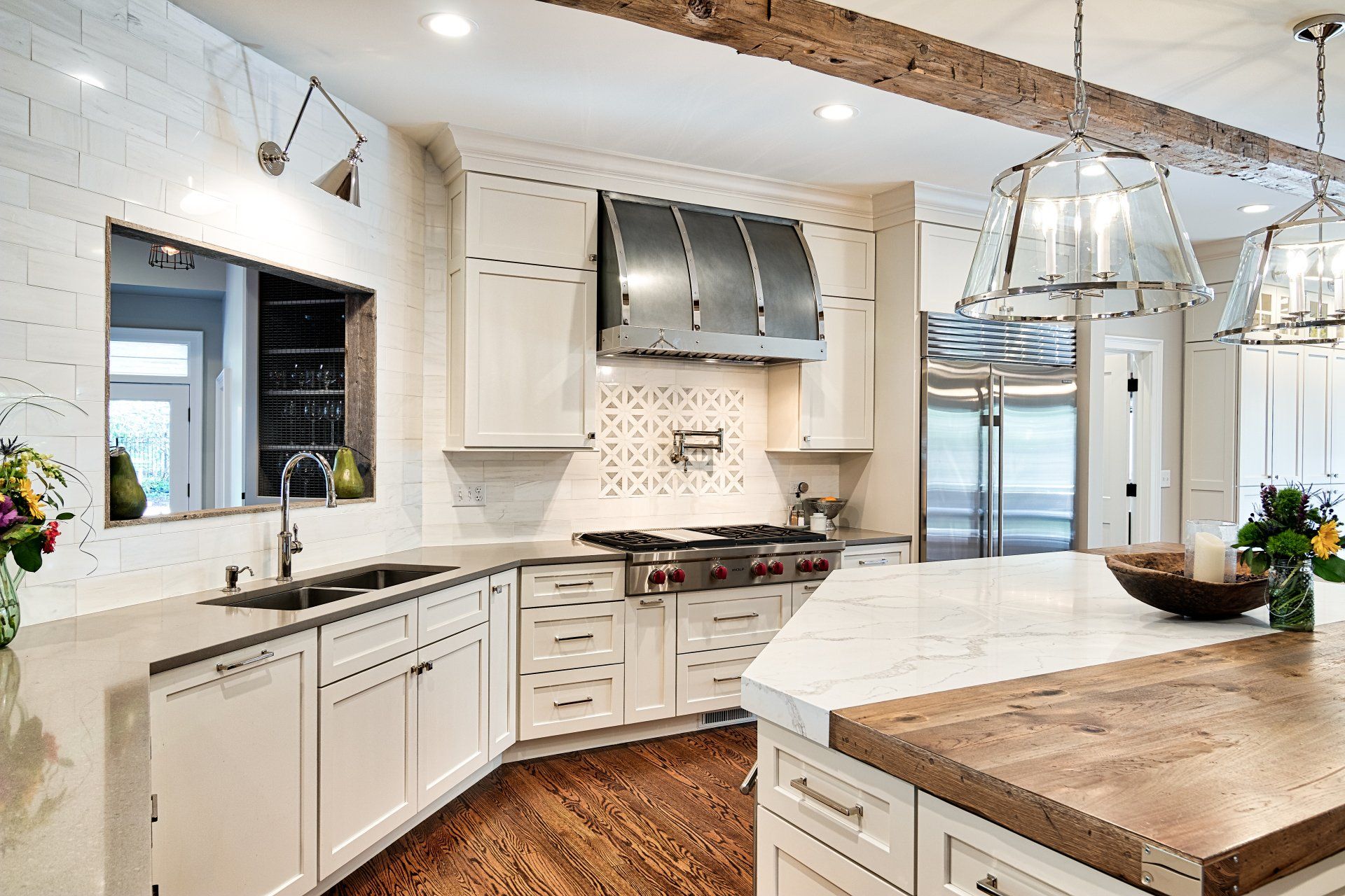 A kitchen with white cabinets , stainless steel appliances , a wooden counter top and a large island.