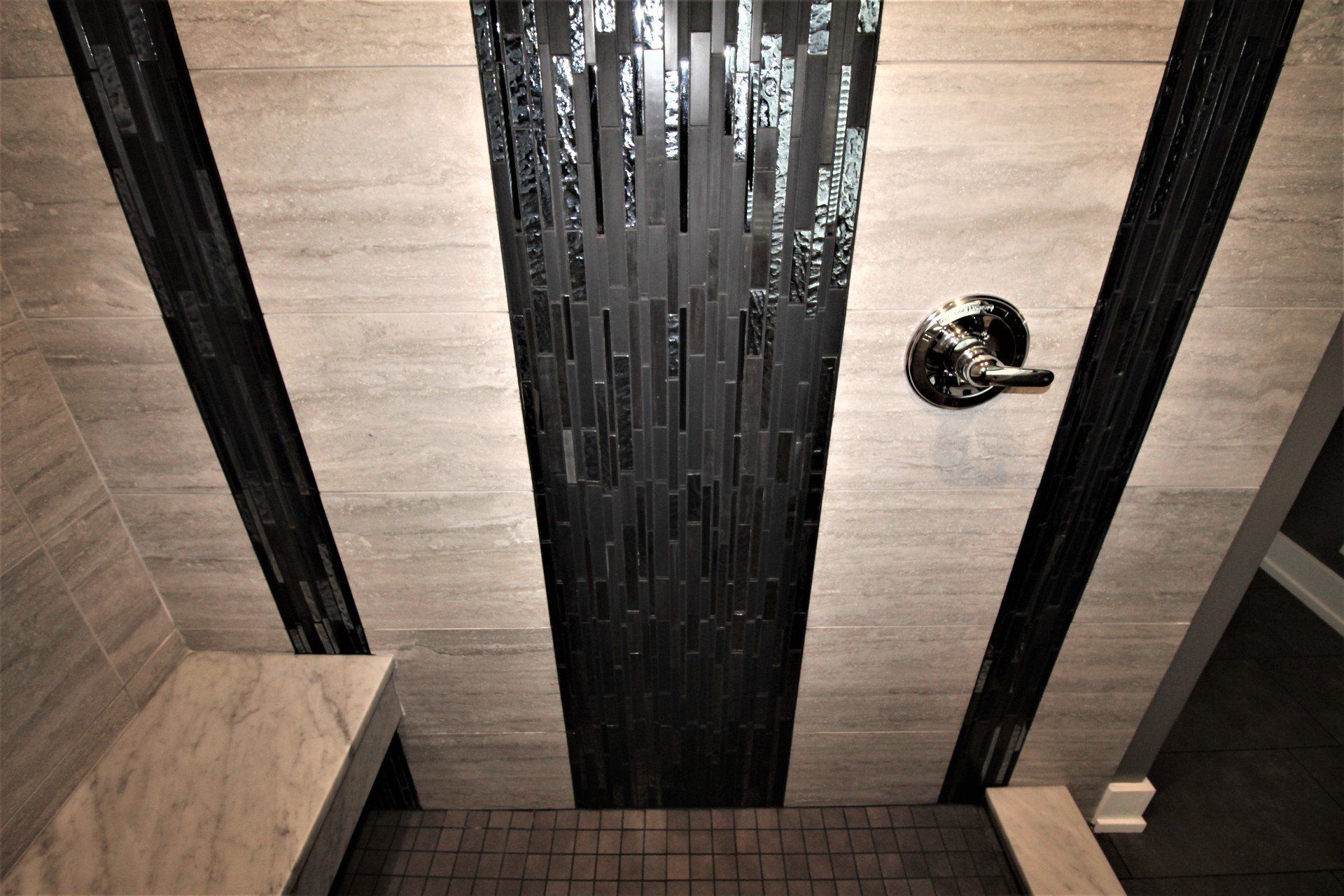 A bathroom with a black and white shower and a bench.