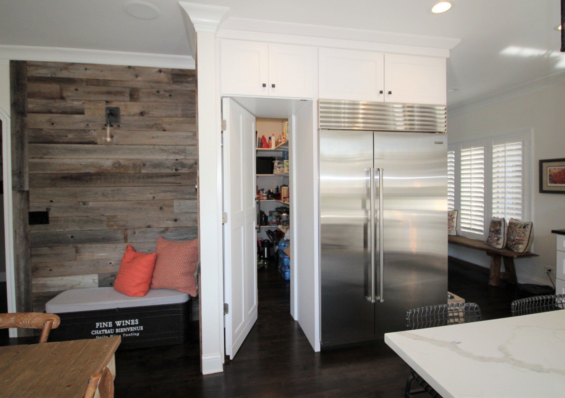 A kitchen with a stainless steel refrigerator and a wooden wall