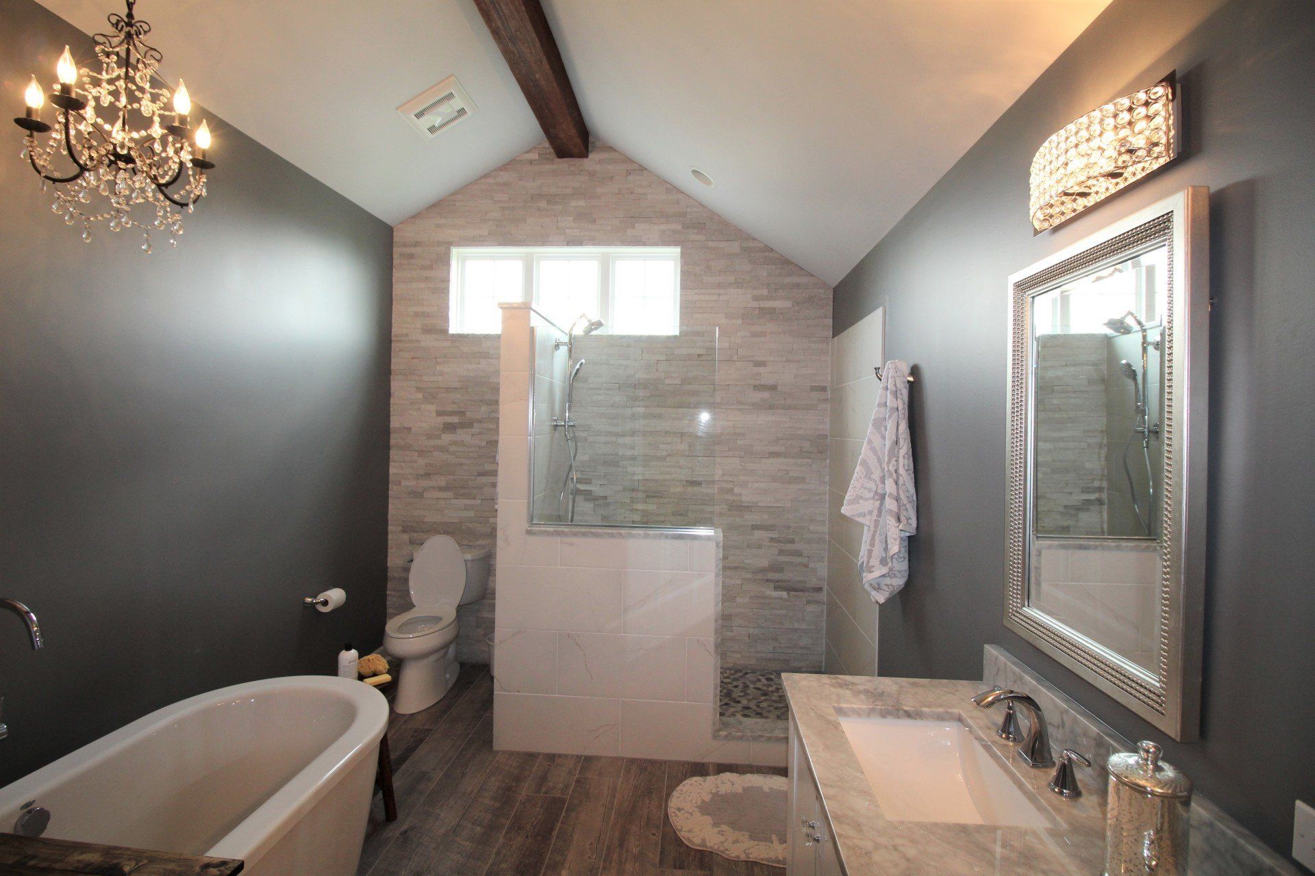 A bathroom with a bathtub , sink , toilet and shower.