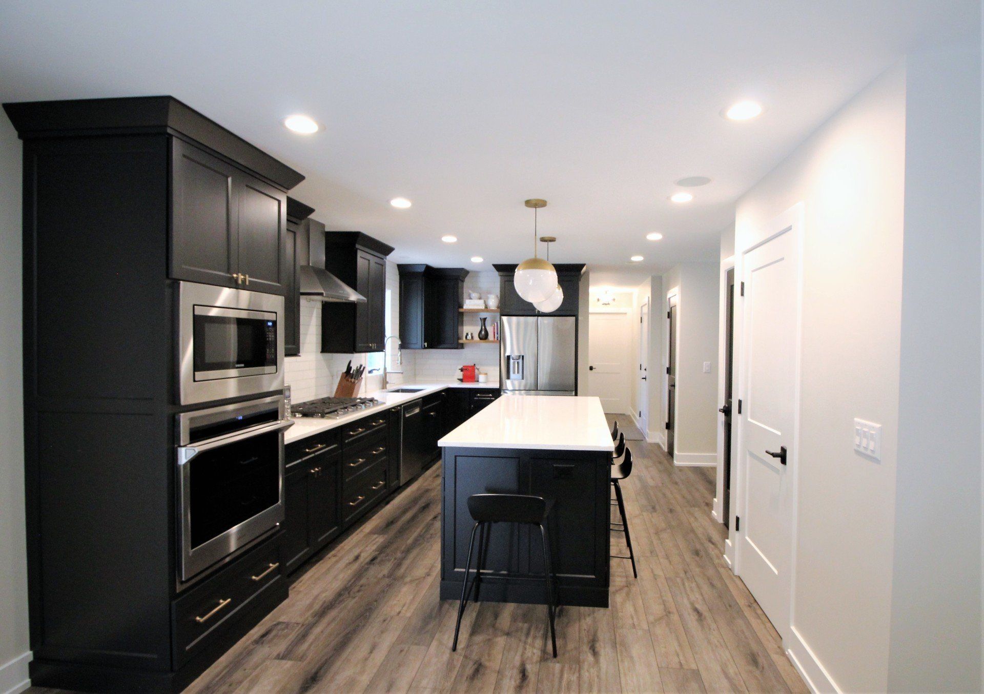 A kitchen with black cabinets and stainless steel appliances