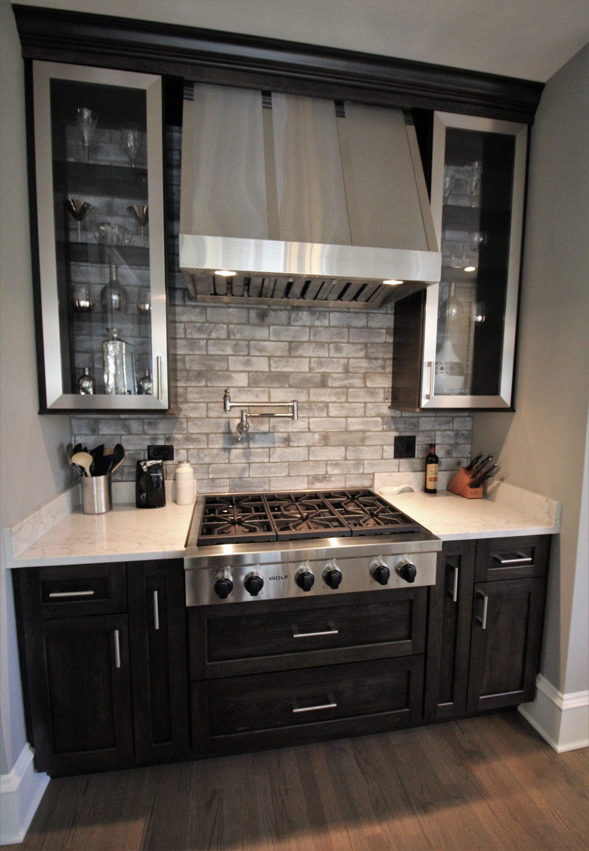 A kitchen with stainless steel appliances and black cabinets