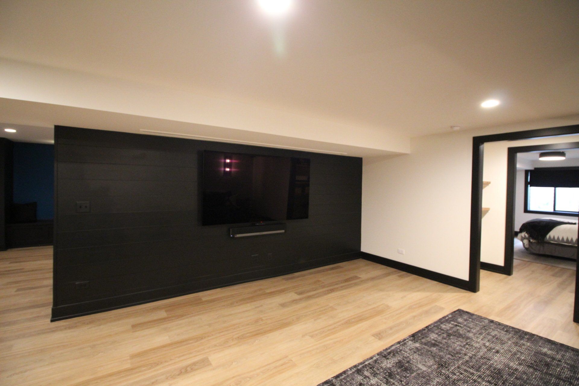 A living room with a large flat screen tv on the wall.