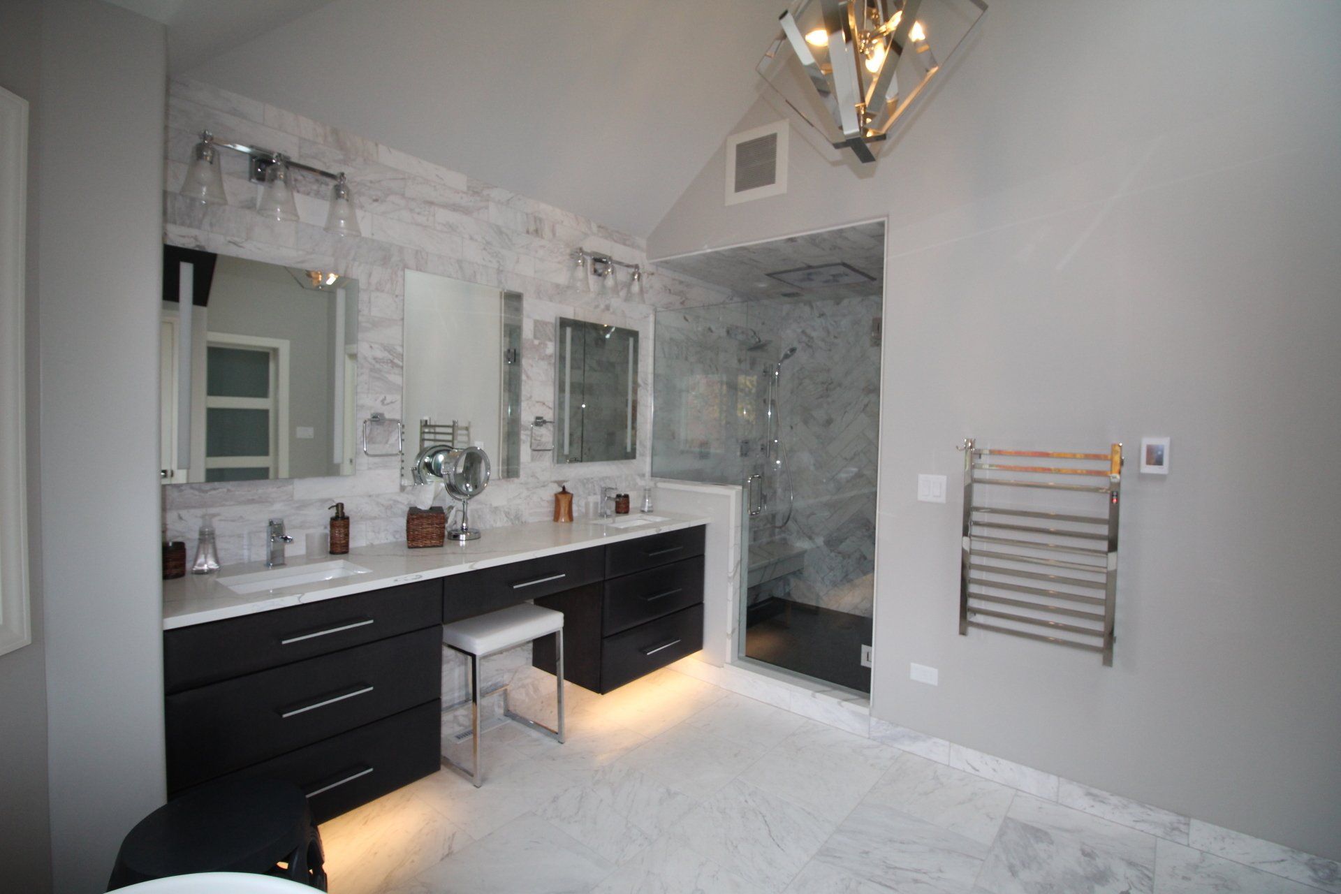 A bathroom with two sinks and a walk in shower.