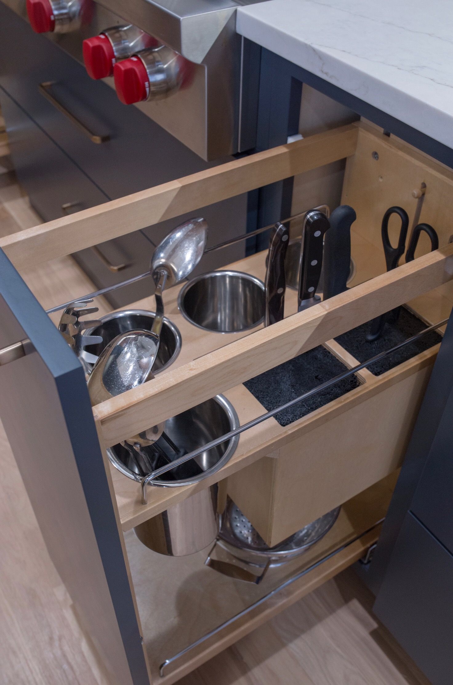 A kitchen drawer filled with pots and pans and utensils.