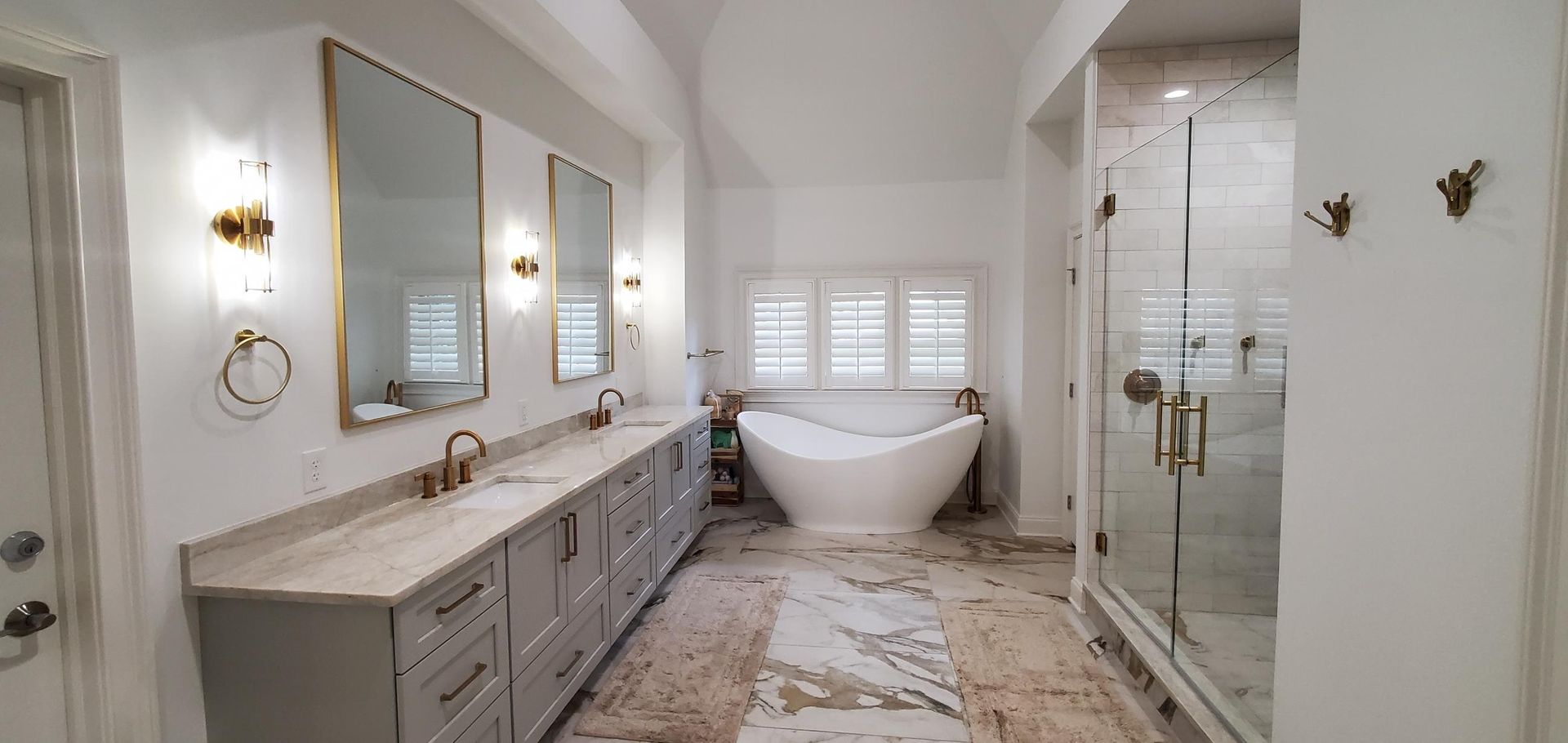 A bathroom with two sinks , a tub , and a shower.