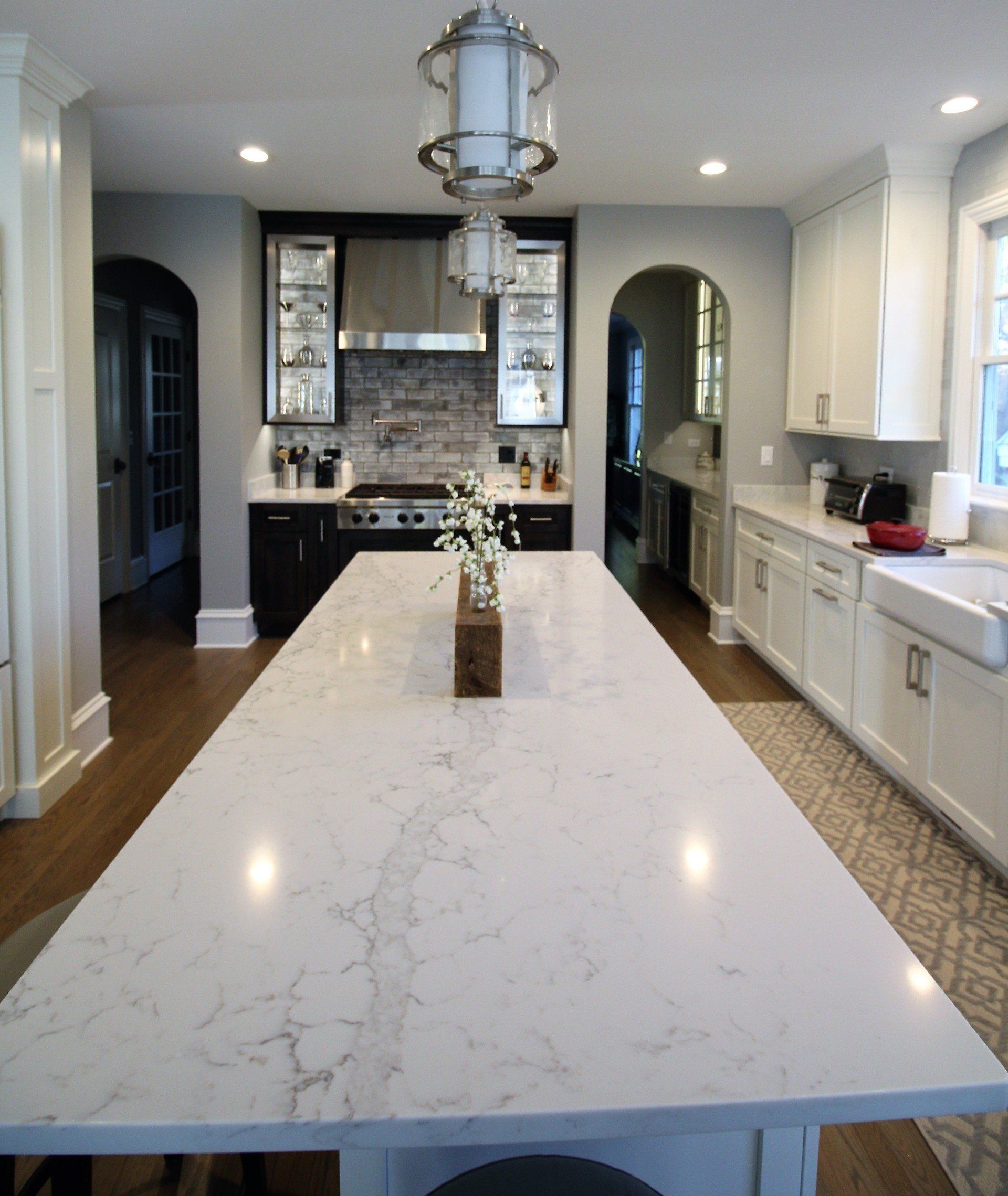 A kitchen with white cabinets and a large white counter top