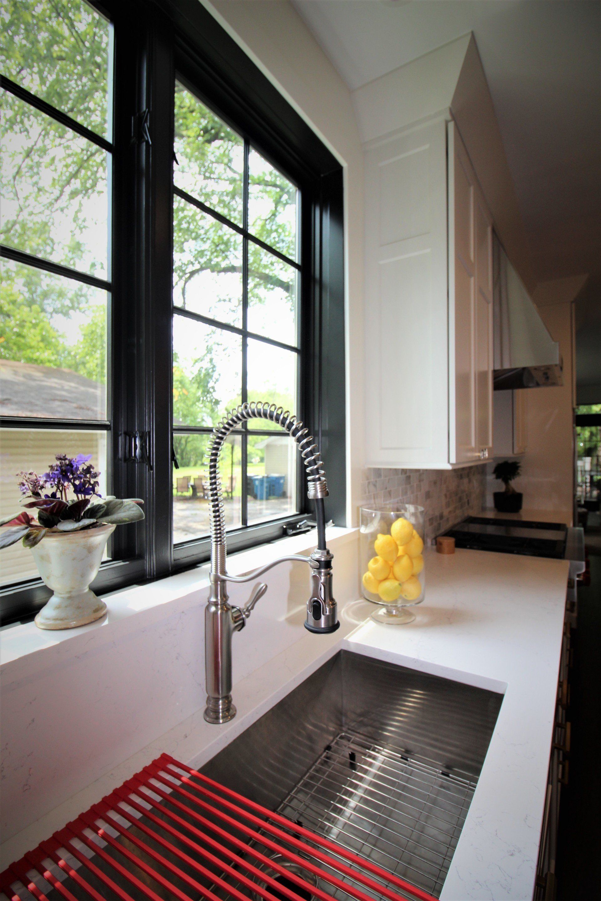 A kitchen sink with a faucet and a window.