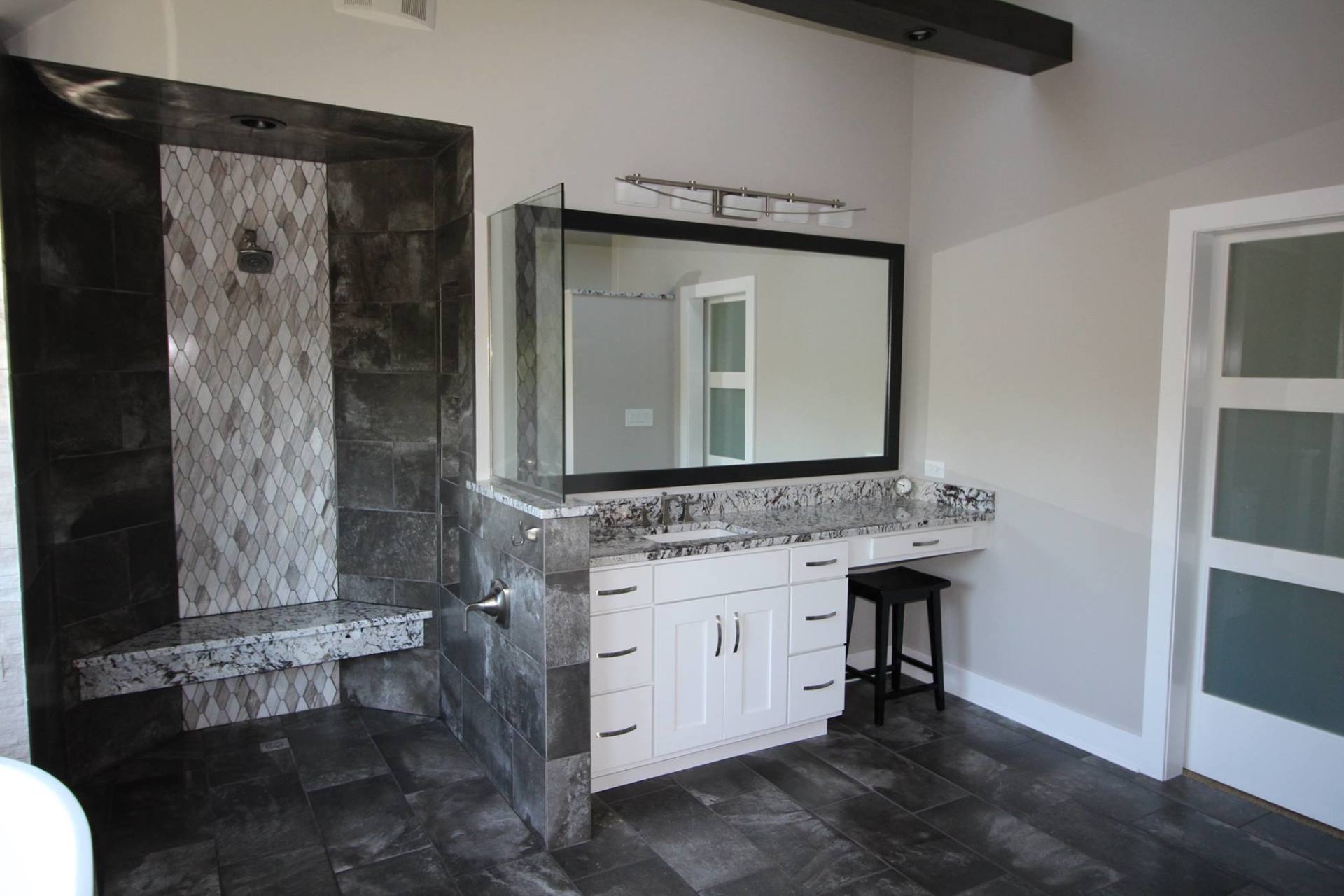 A bathroom with a sink , mirror and shower.
