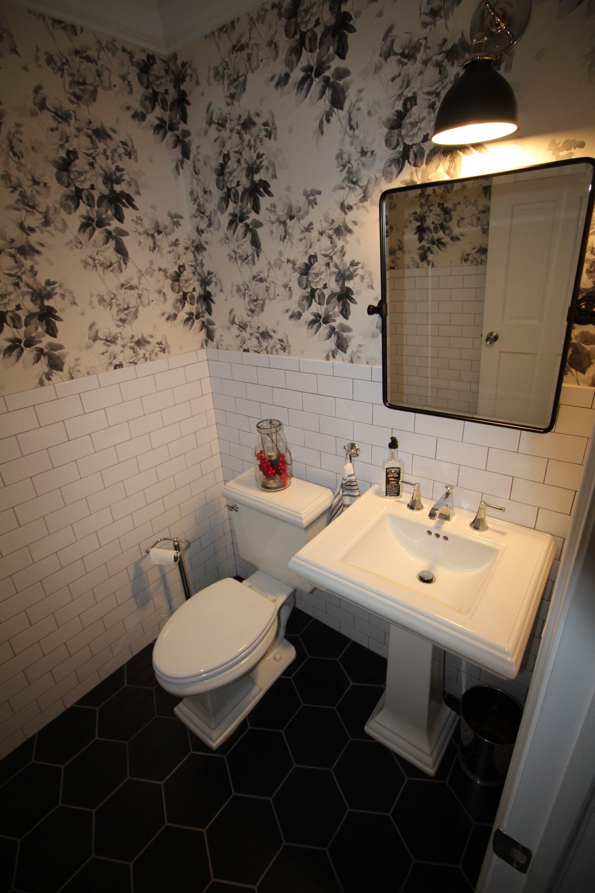 A bathroom with a toilet a sink and a mirror