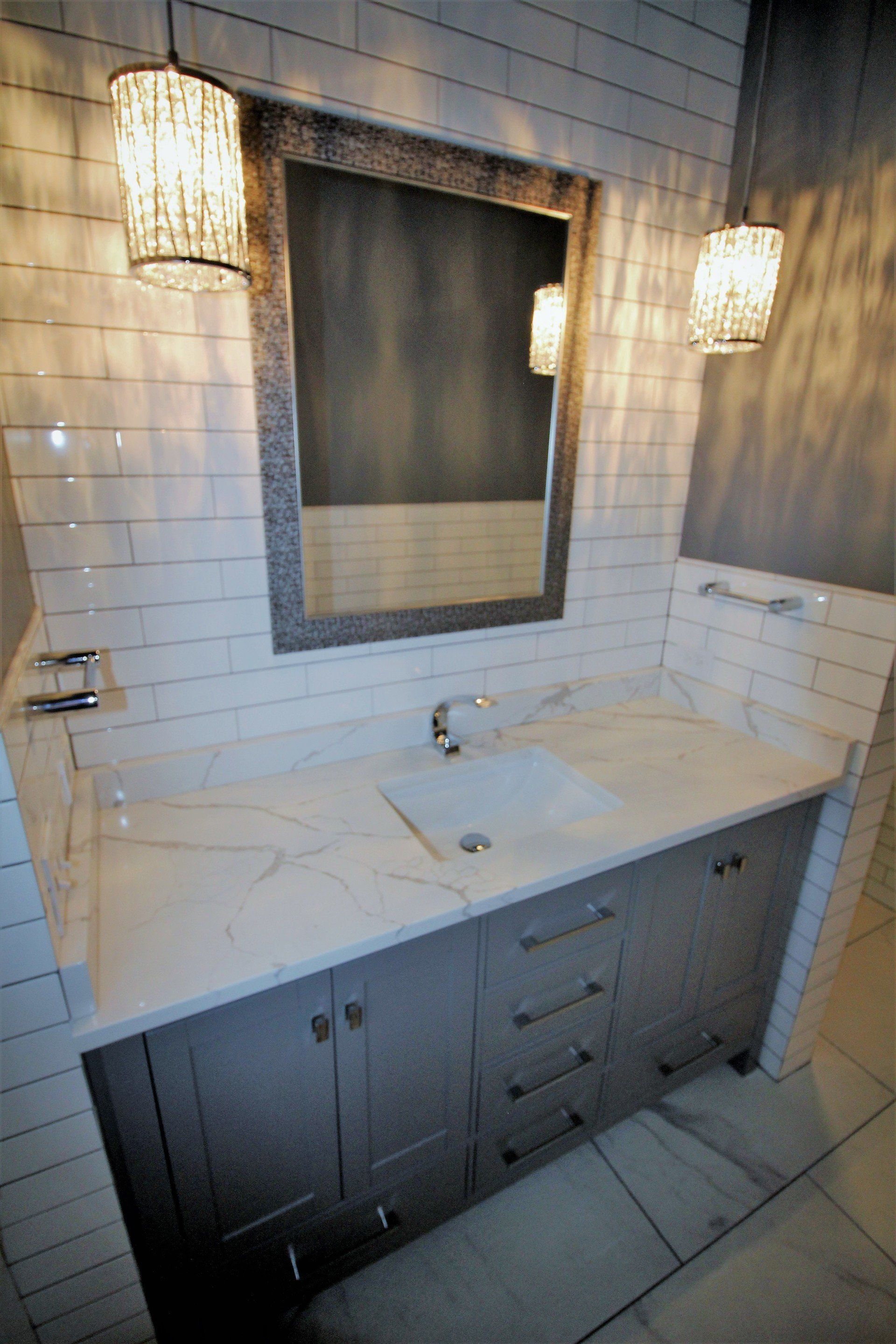 A bathroom with a sink , mirror and cabinets