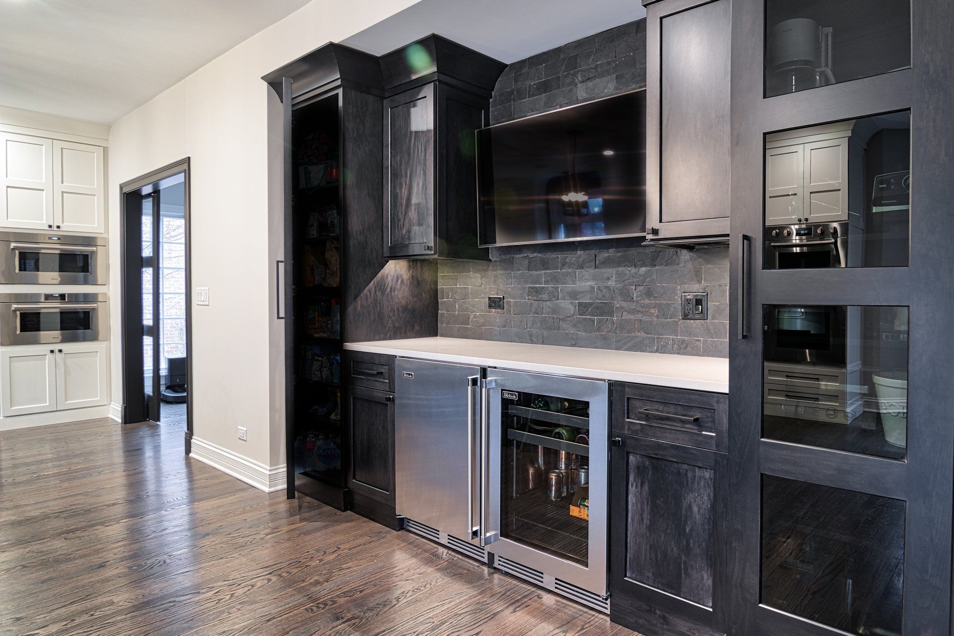 A kitchen with black cabinets and stainless steel appliances