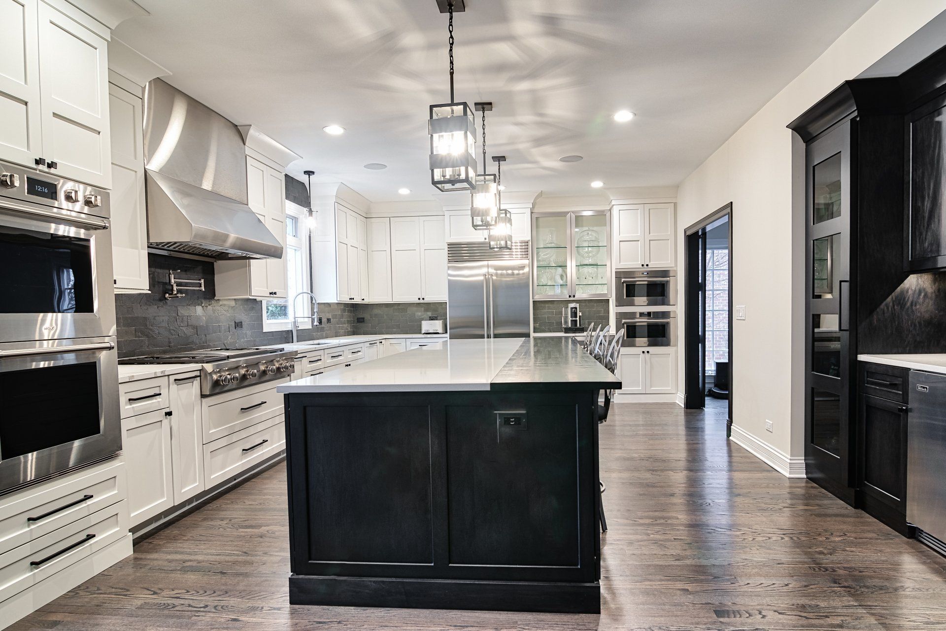 A large kitchen with black cabinets and stainless steel appliances.