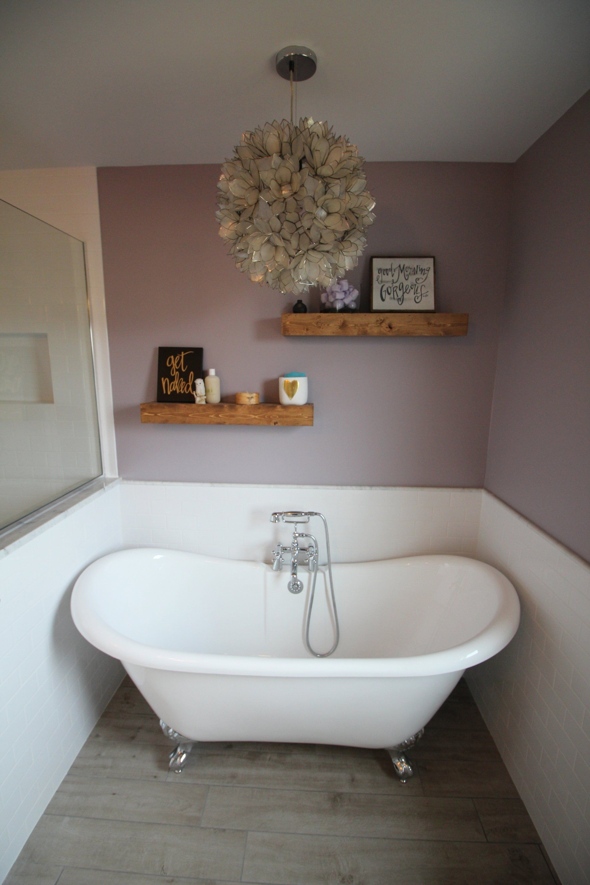 A bathtub in a bathroom with purple walls