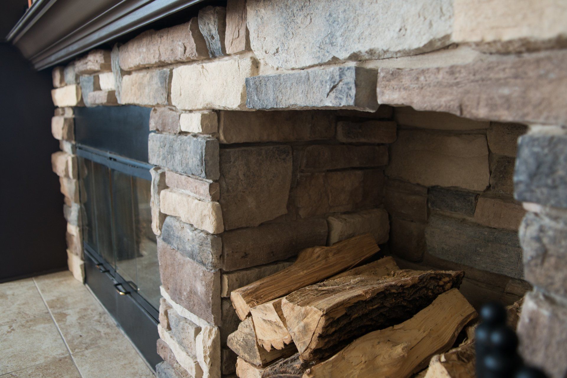 A fireplace with a pile of logs underneath it
