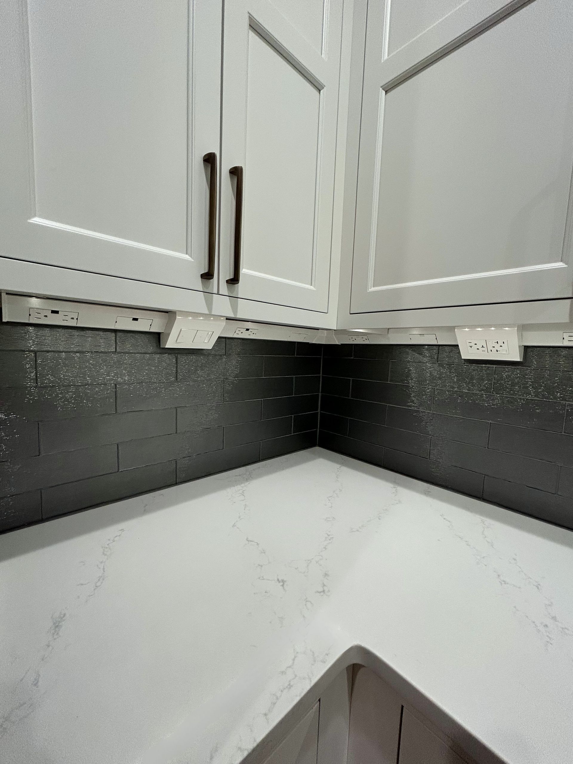 A kitchen corner with white cabinets and a sink