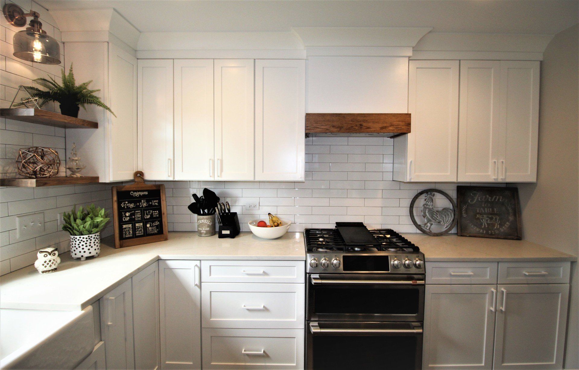 A kitchen with white cabinets , a stove , and a sink.
