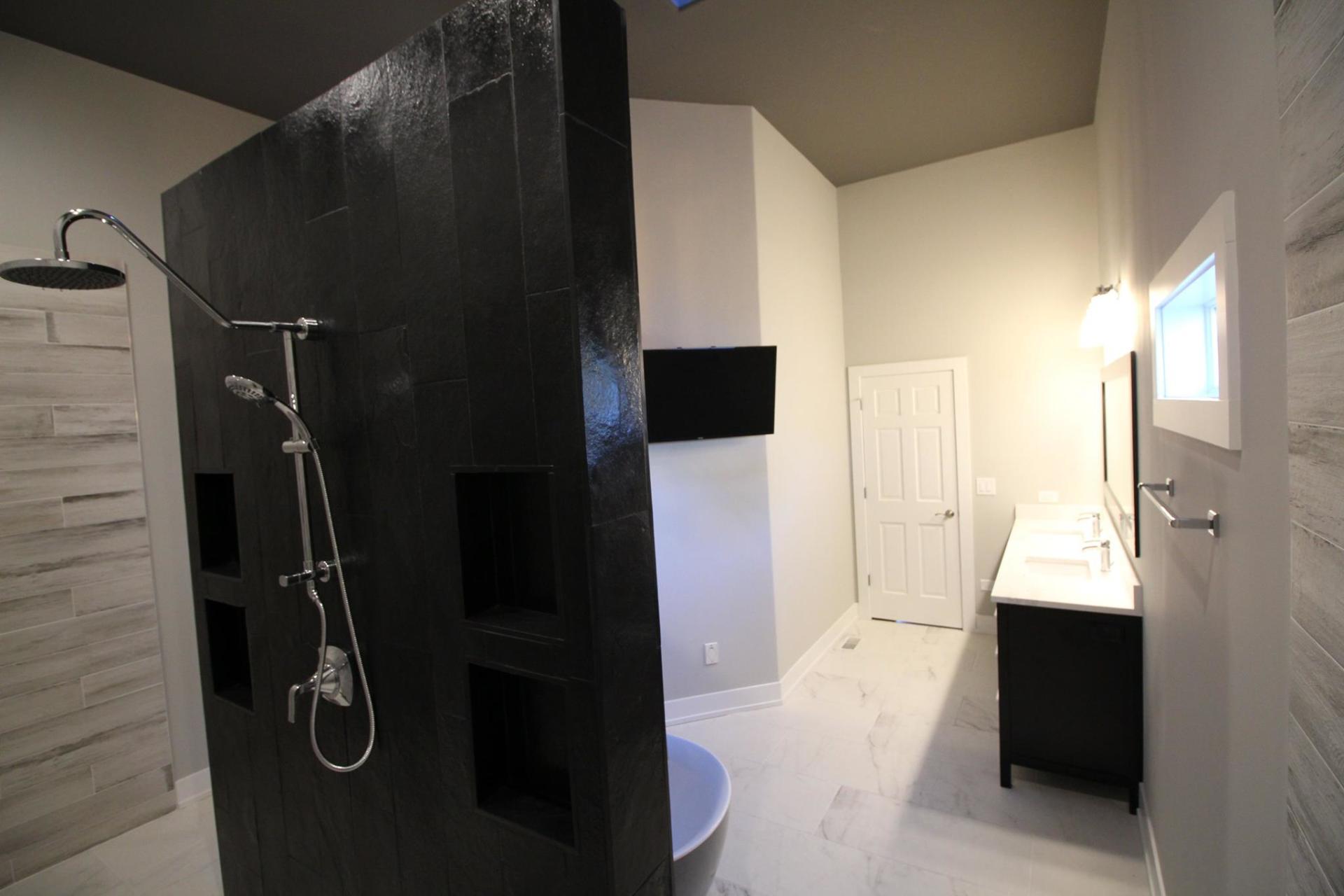 A bathroom with a walk in shower and two sinks.