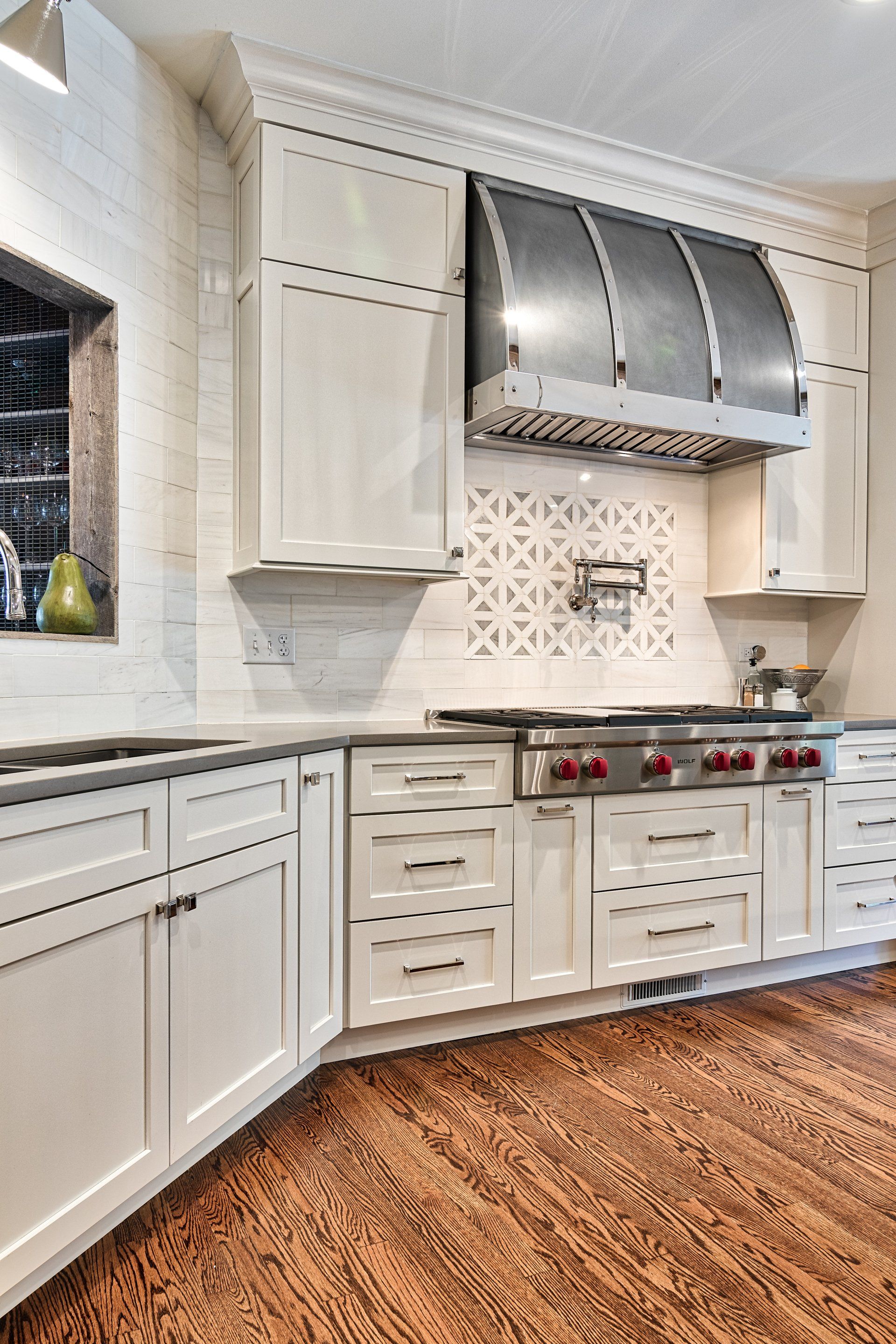 A kitchen with white cabinets and stainless steel appliances
