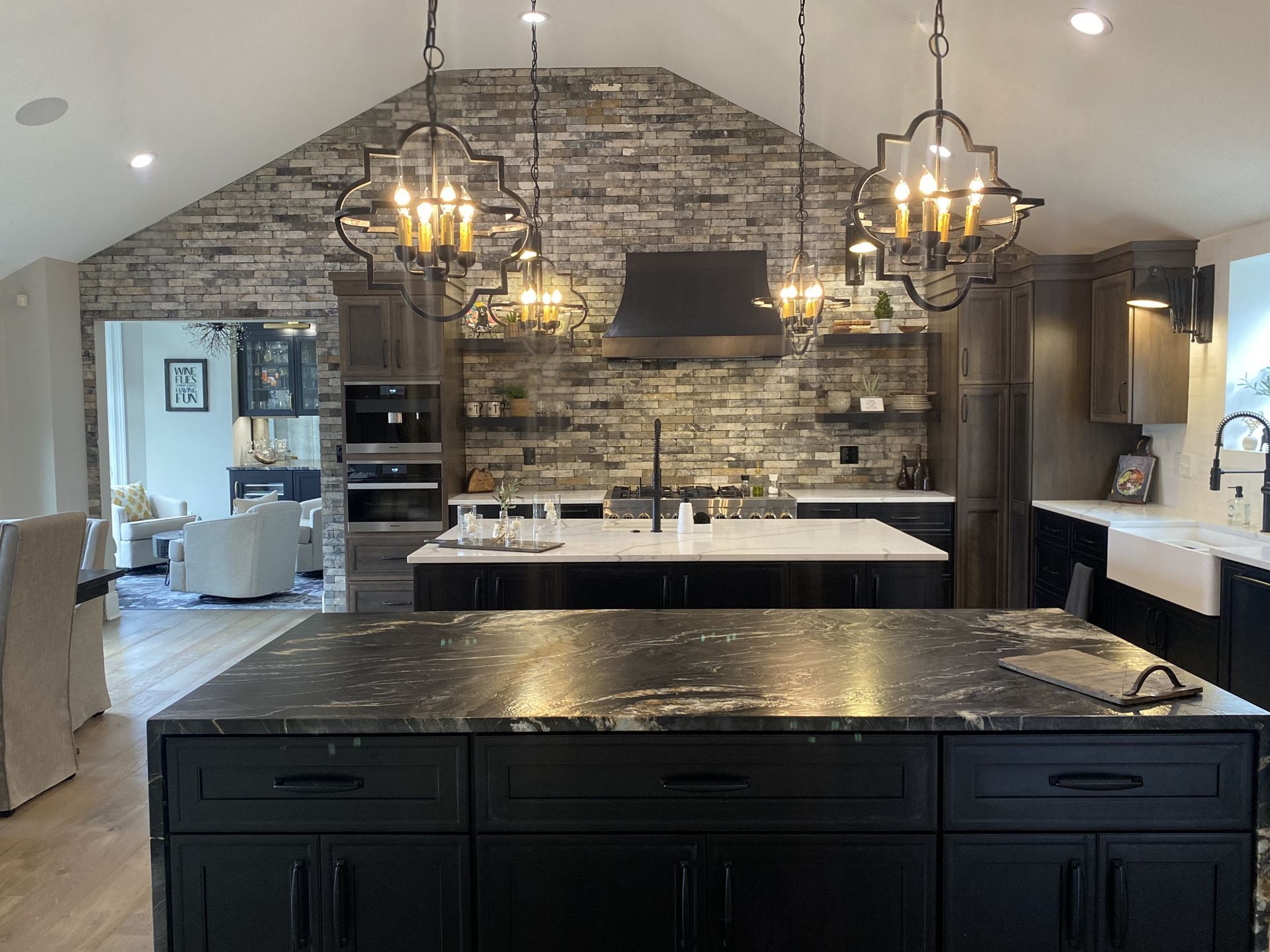 A kitchen with a large island and a brick wall.