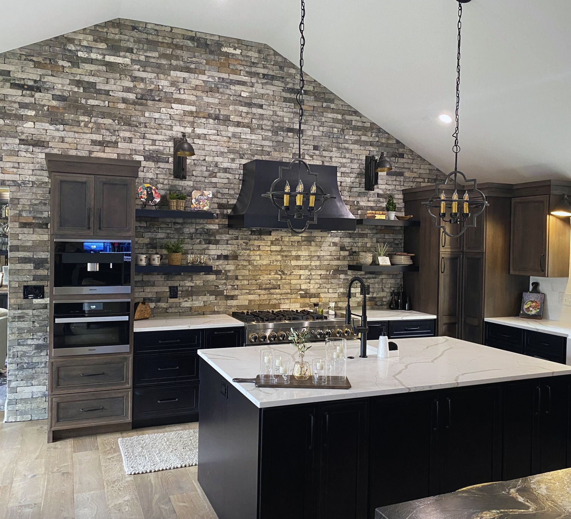 A kitchen with a large island and a brick wall
