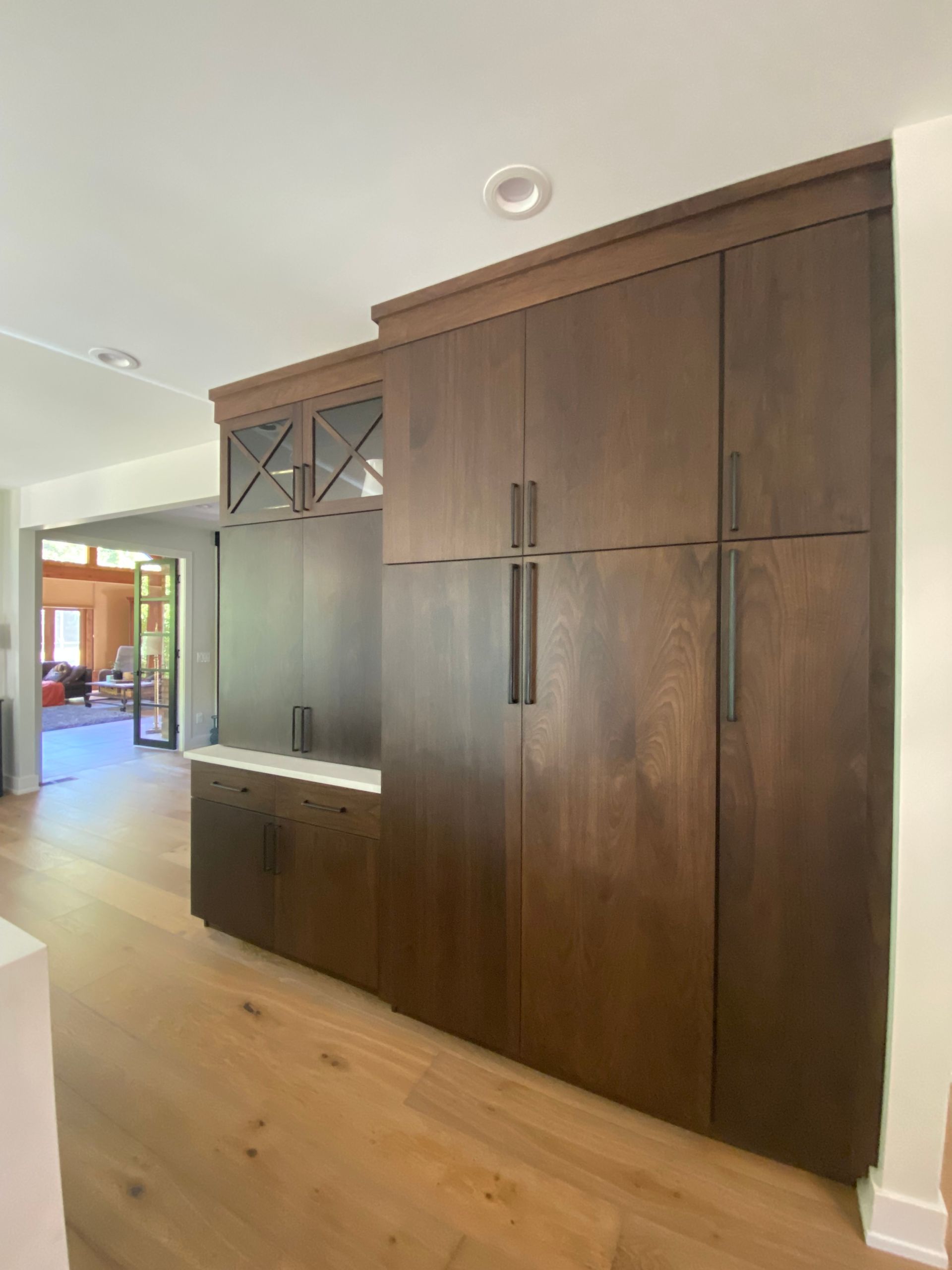 A kitchen with a lot of wooden cabinets and a refrigerator.