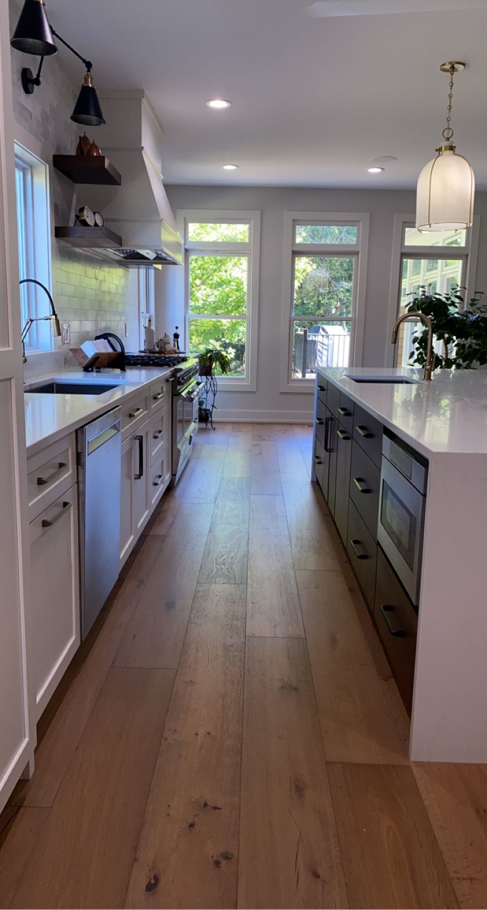 A kitchen with white cabinets , stainless steel appliances , and hardwood floors.