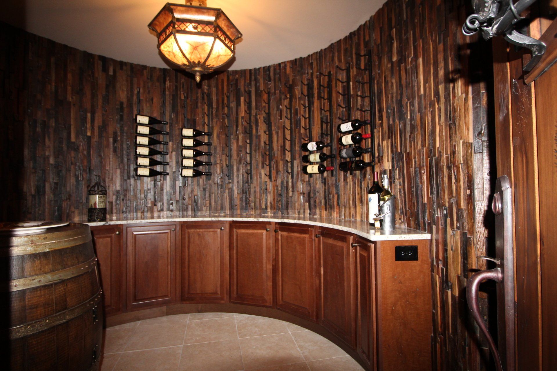 A wine cellar with wooden cabinets and barrels and a bottle of wine on the counter.