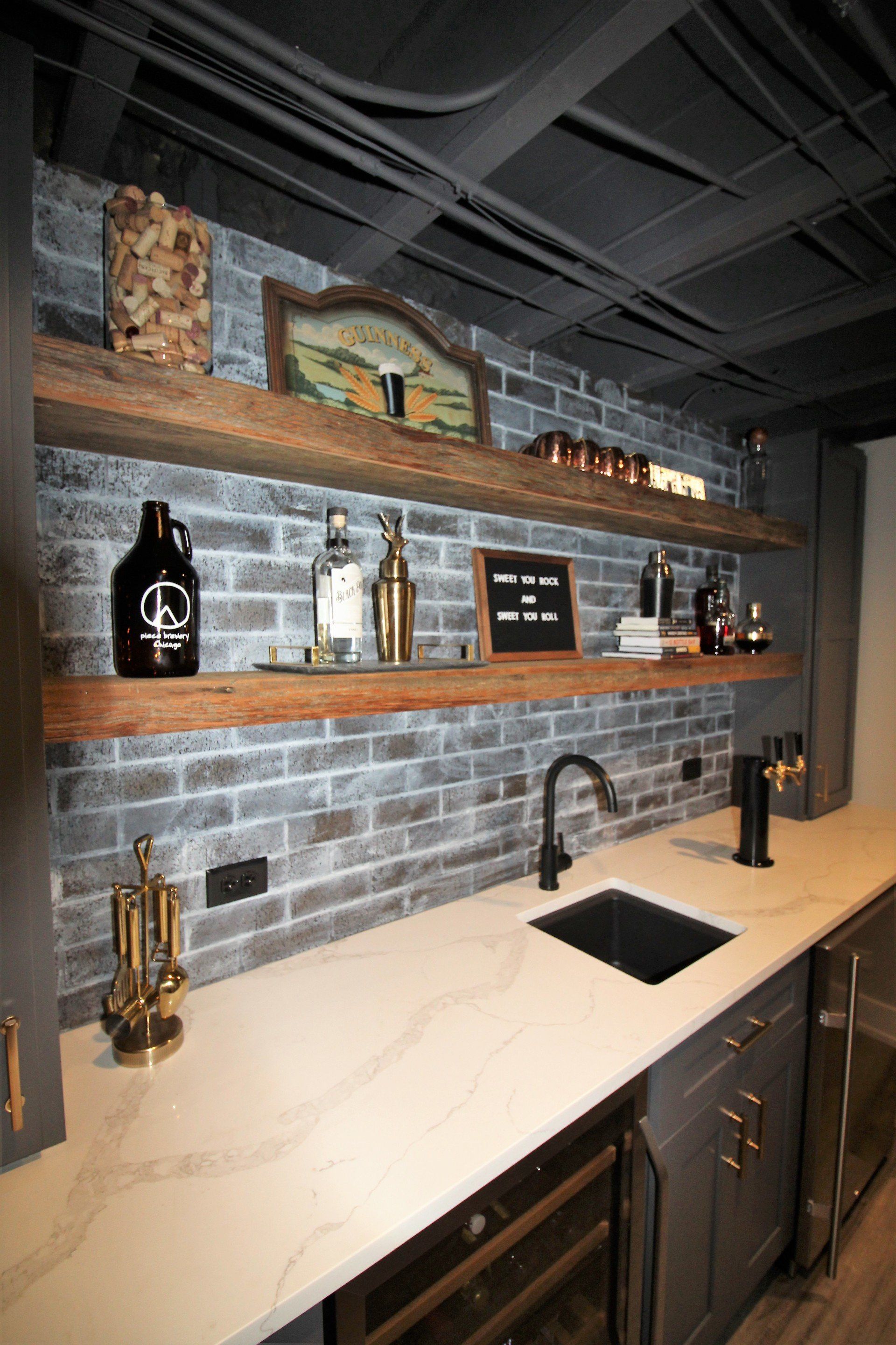 A kitchen with a sink , shelves , and a brick wall.