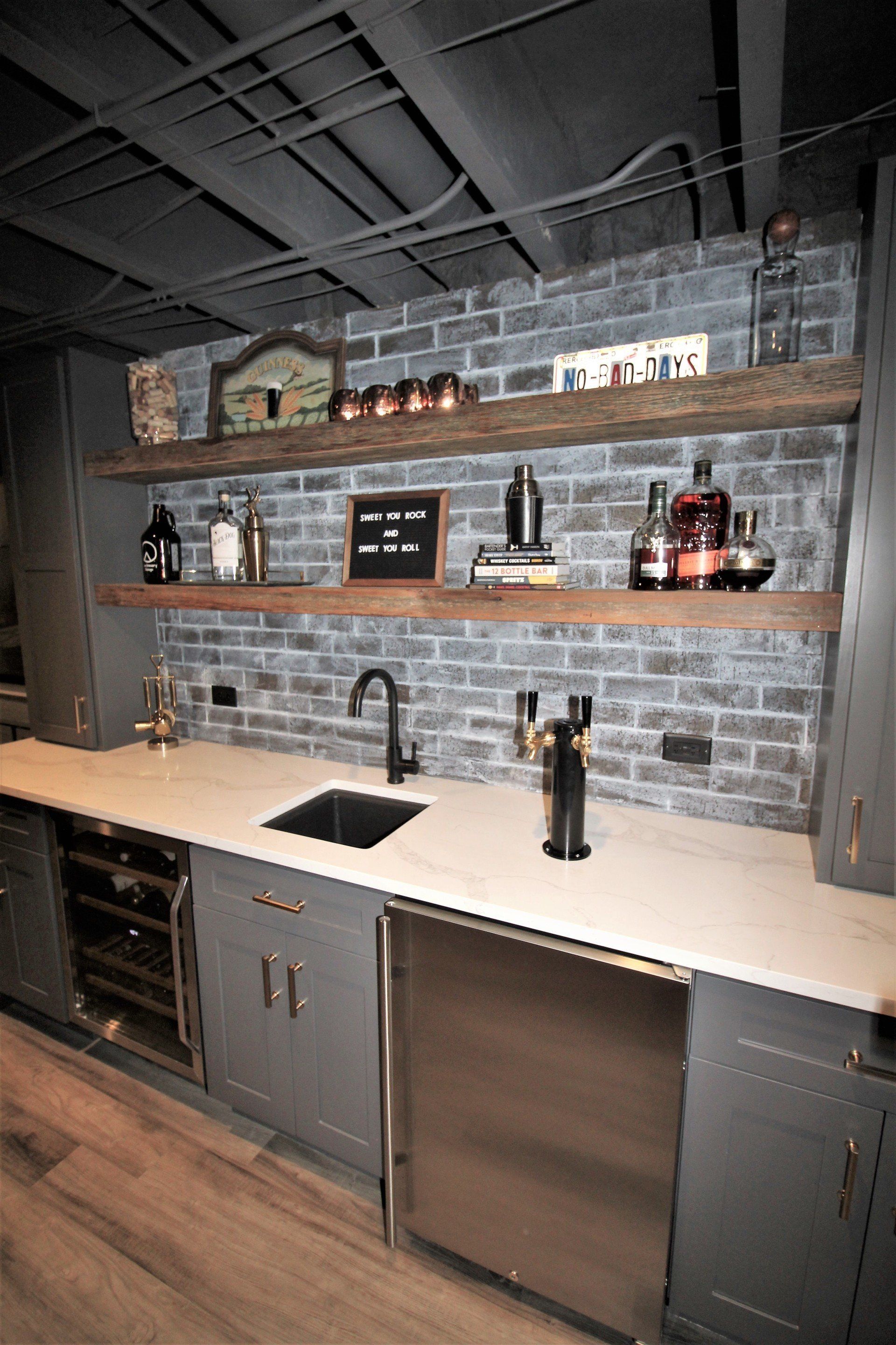 A kitchen with a brick wall , stainless steel appliances , and a sink.