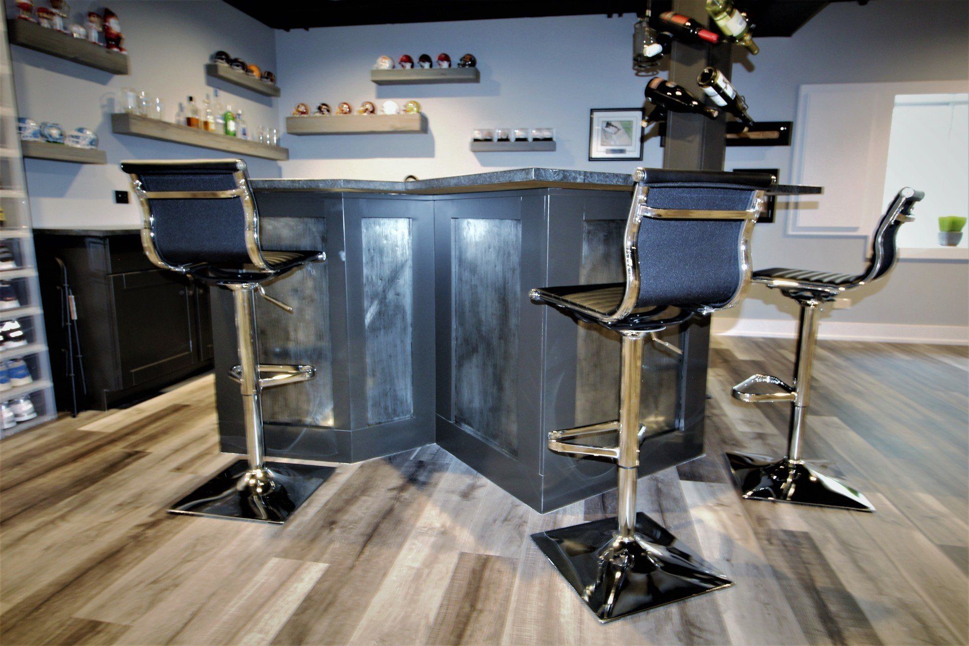 A bar with three bar stools in a basement