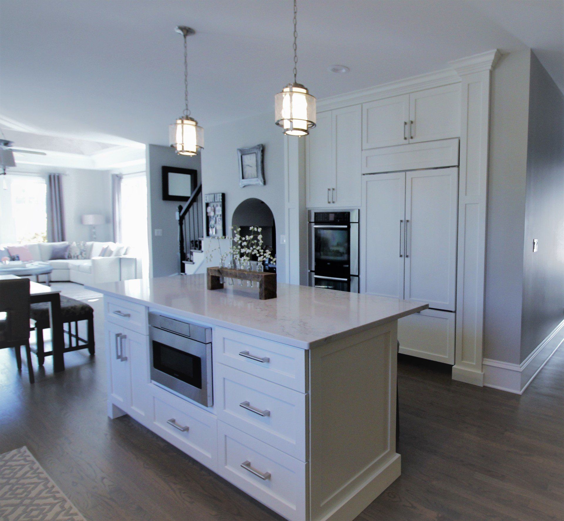 A kitchen with white cabinets and a large island