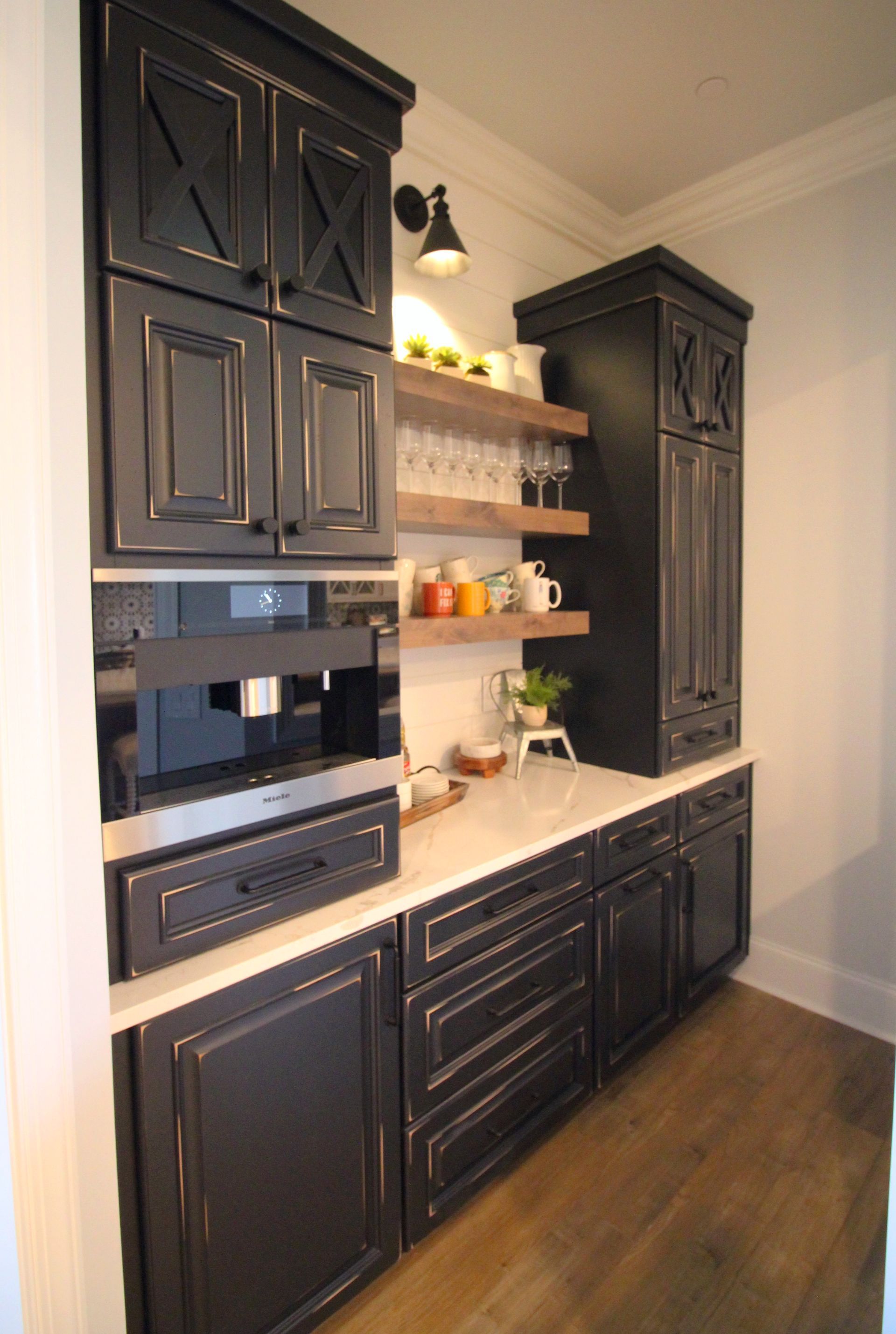 A kitchen with black cabinets and stainless steel appliances.