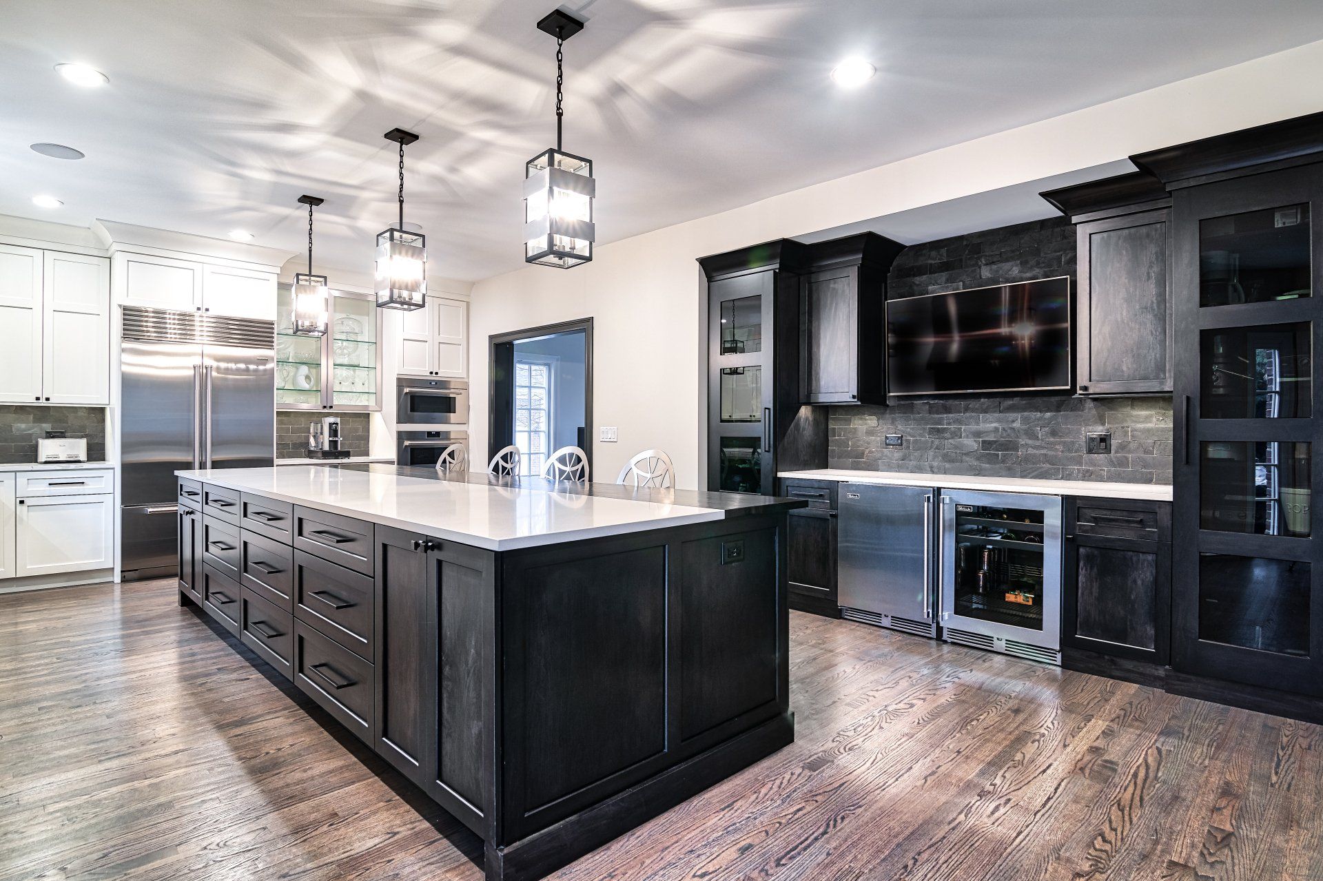 A large kitchen with a large island in the middle and stainless steel appliances.