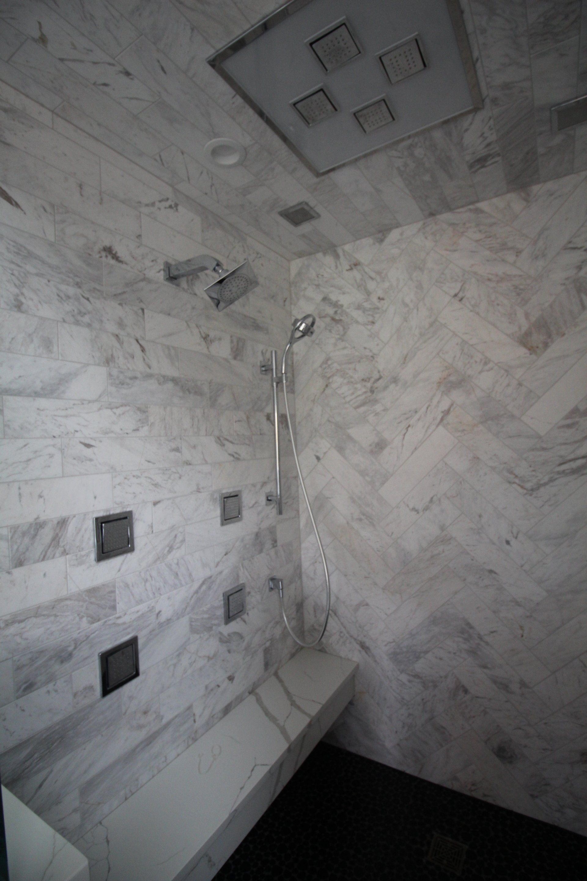 A bathroom with a shower and a bench.