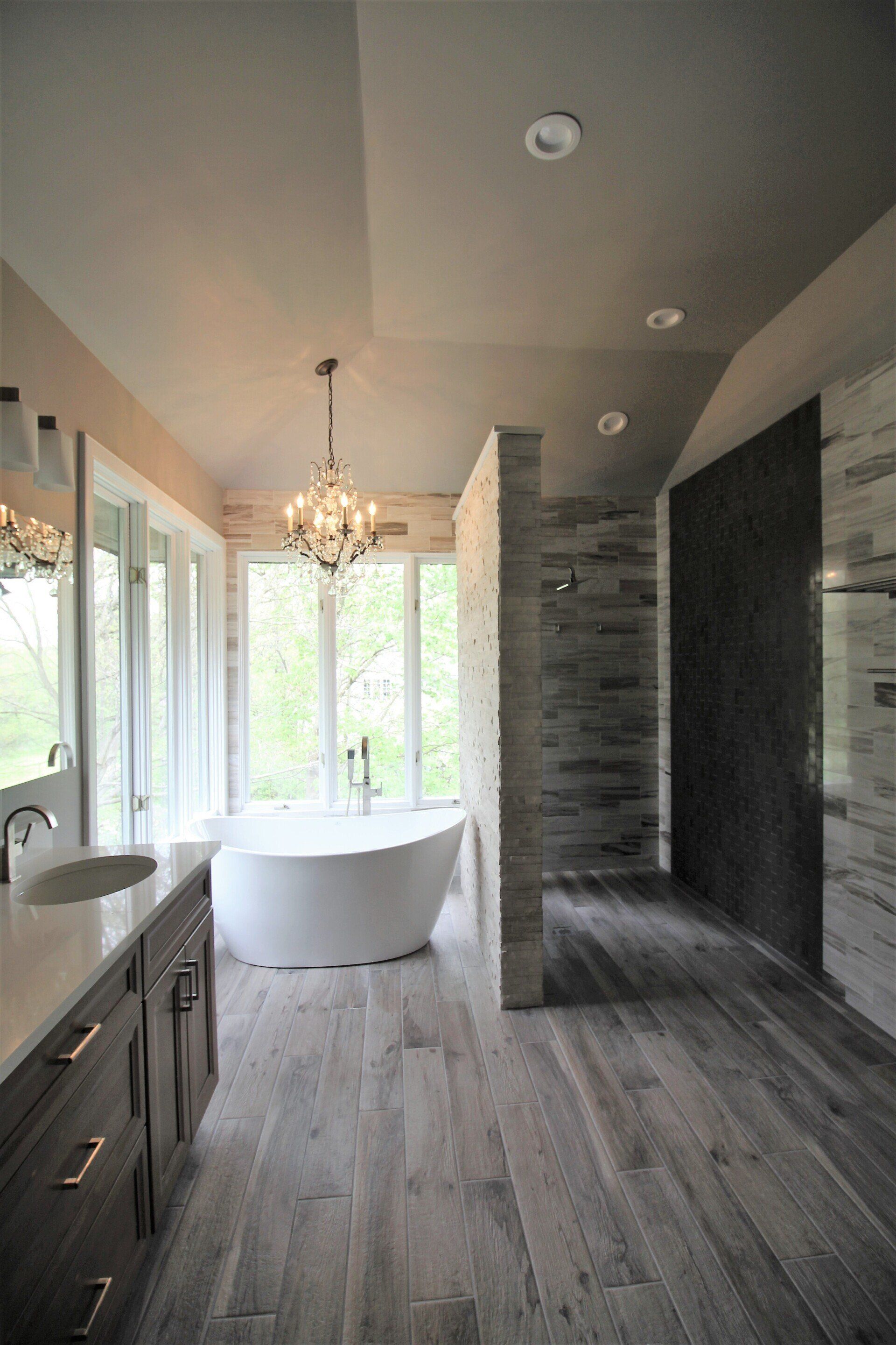A bathroom with a tub , sink , and shower.