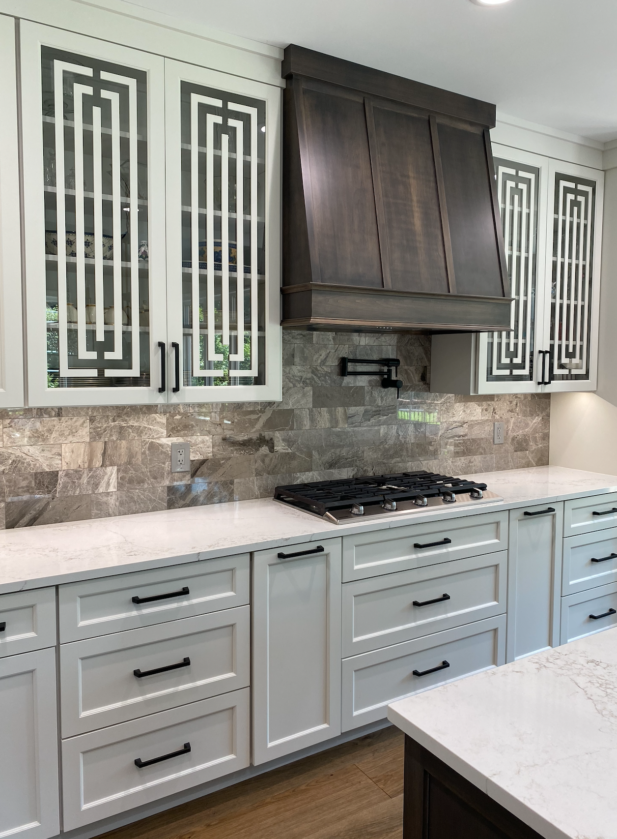 A kitchen with white cabinets and a stove top oven.