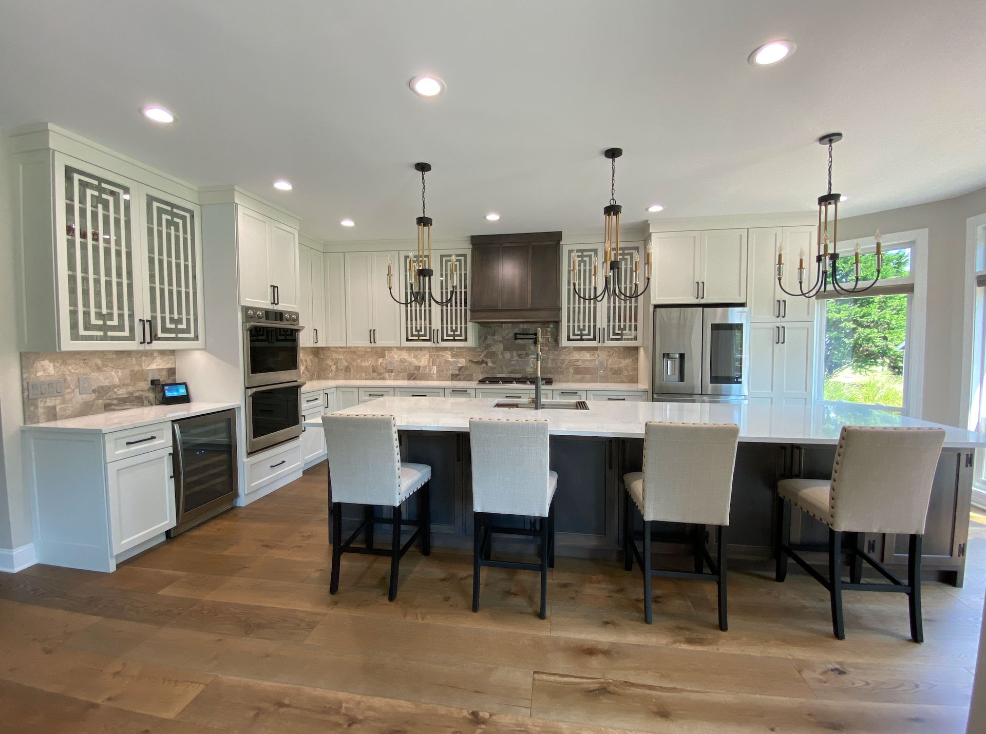 A kitchen with a large island and chairs in it.