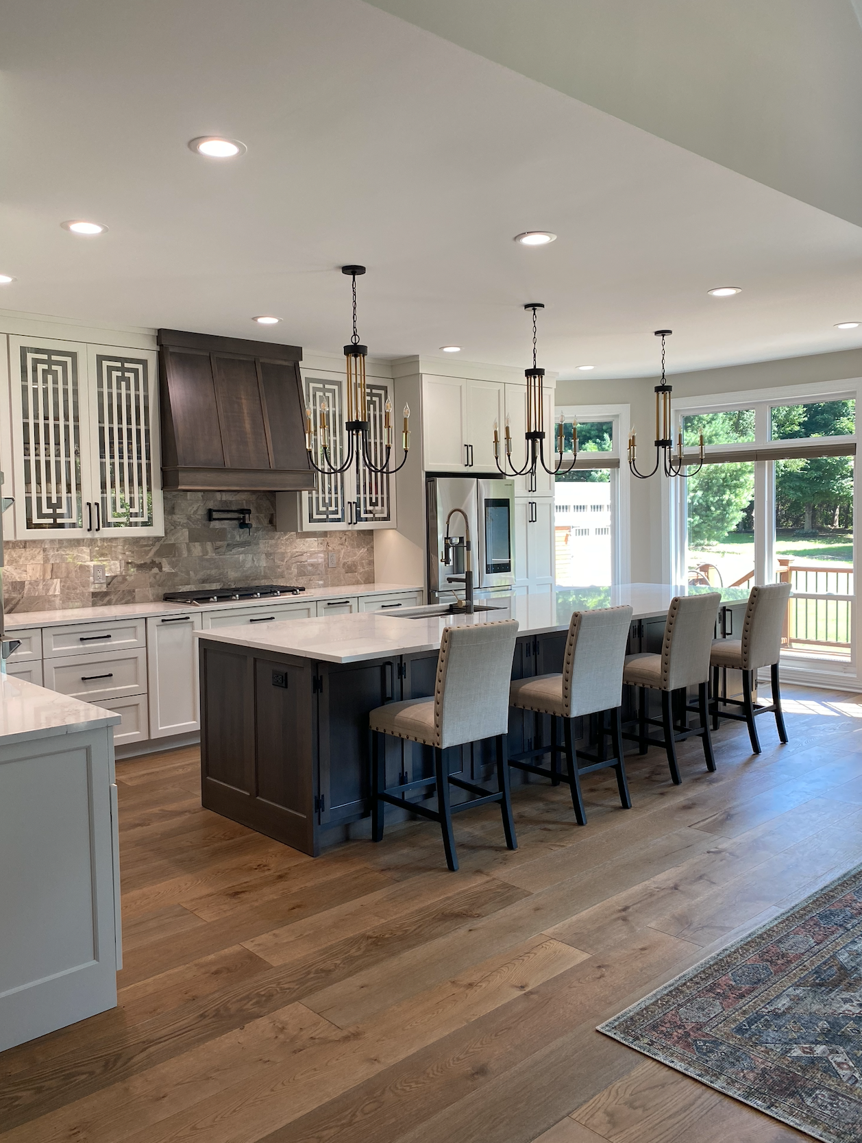 A kitchen with a large island and chairs in it.