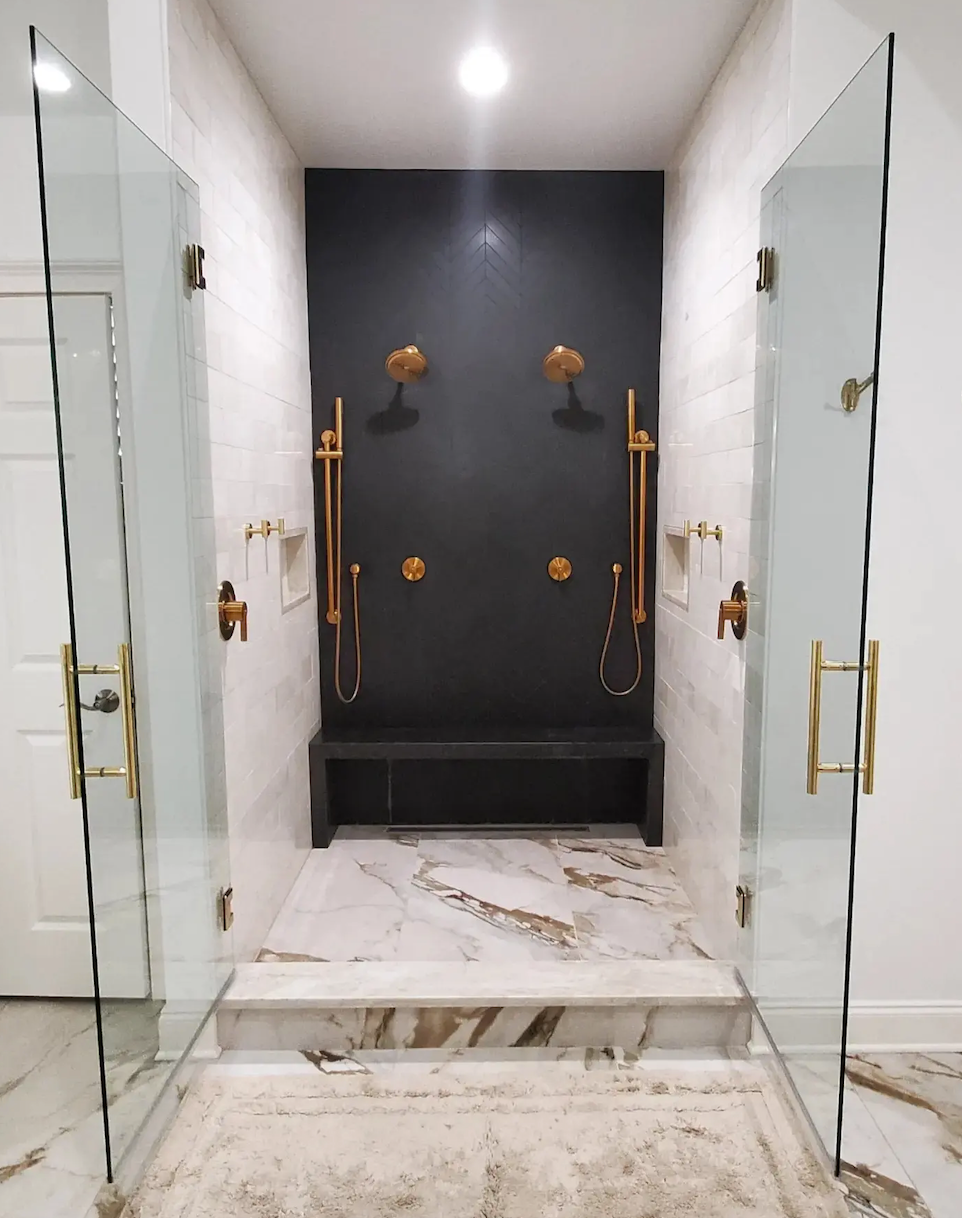 A bathroom with two showers and a bench in it