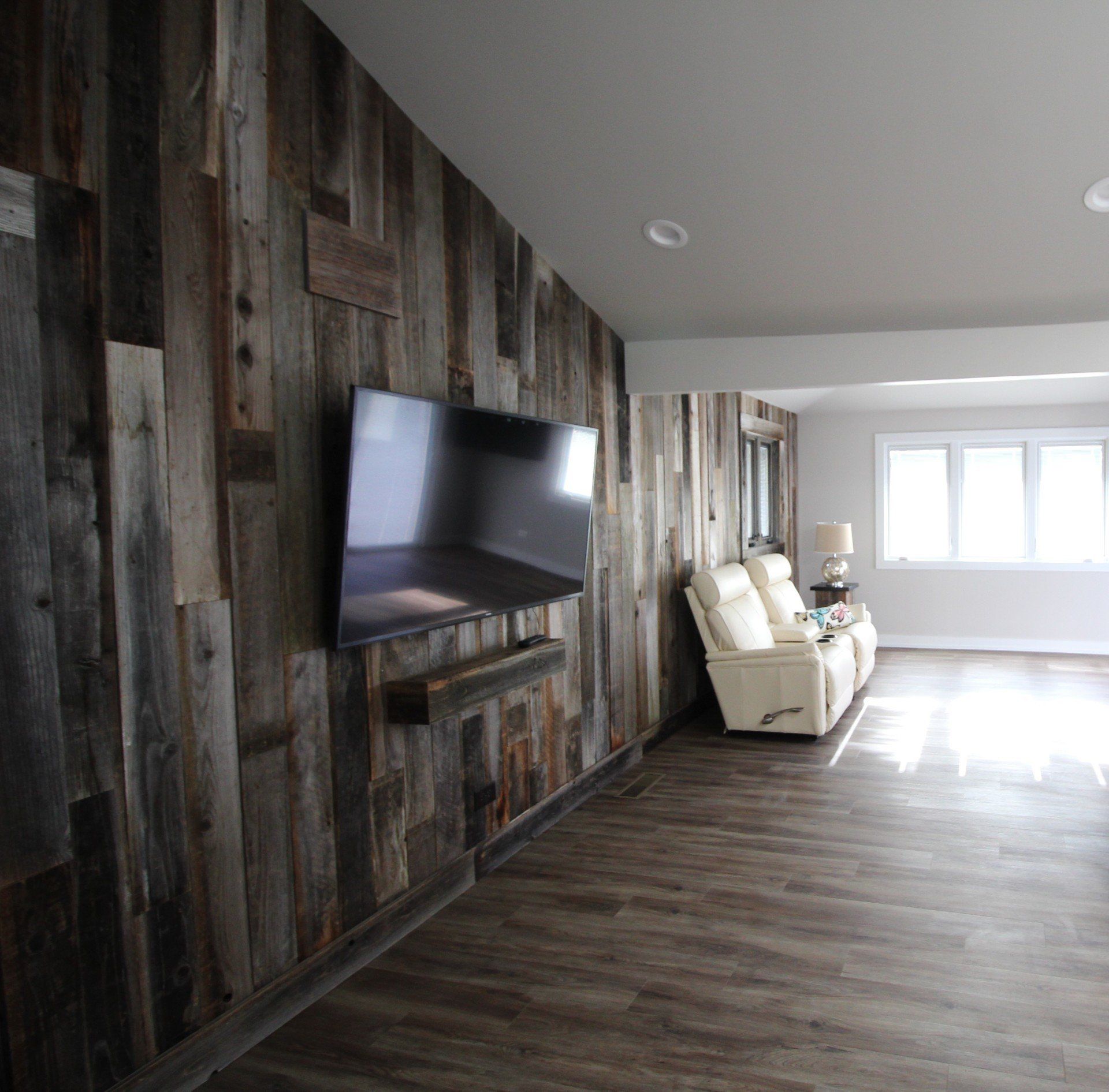 A living room with wood paneling and a flat screen tv