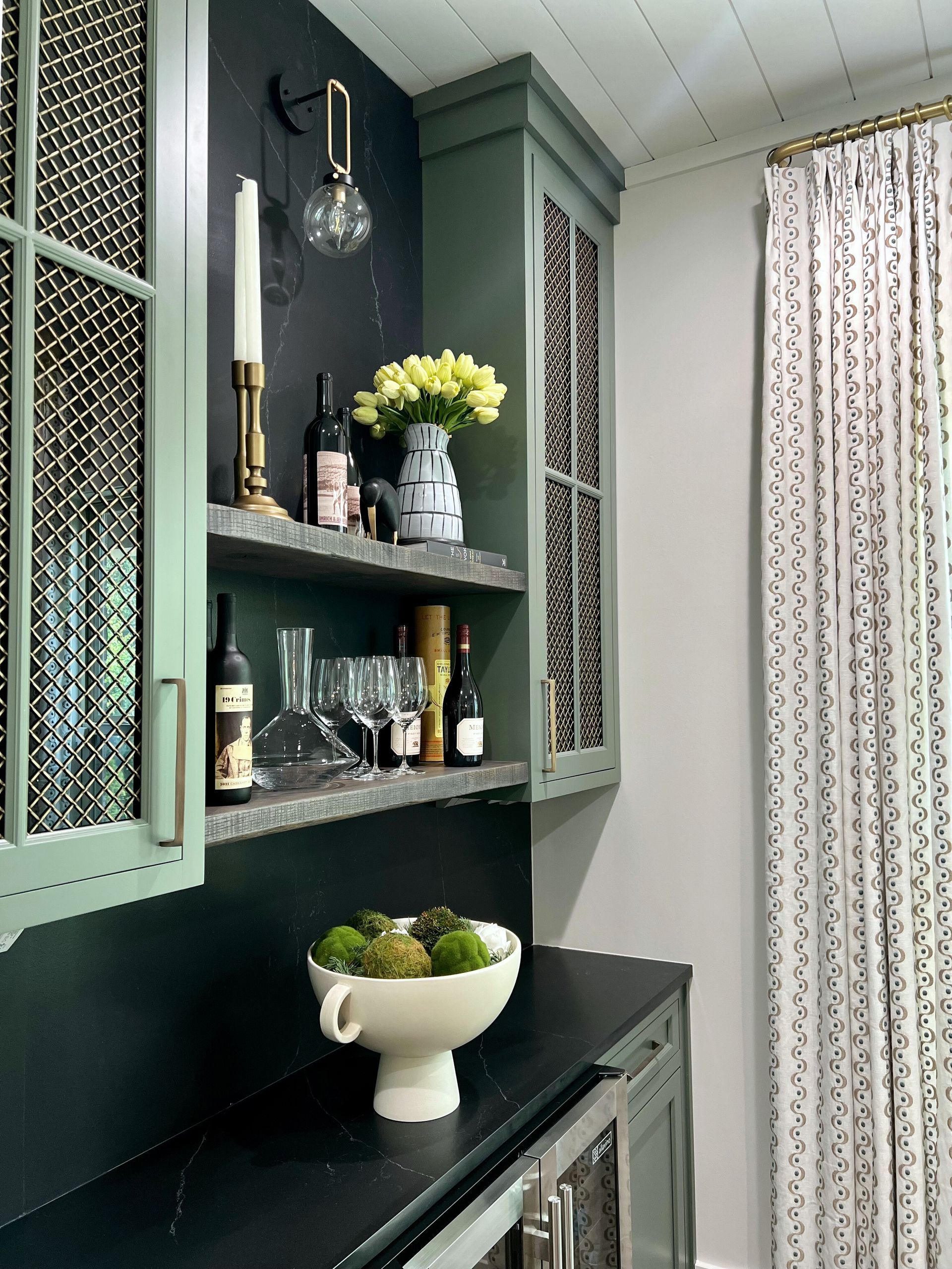 A bowl of flowers sits on a counter in a kitchen